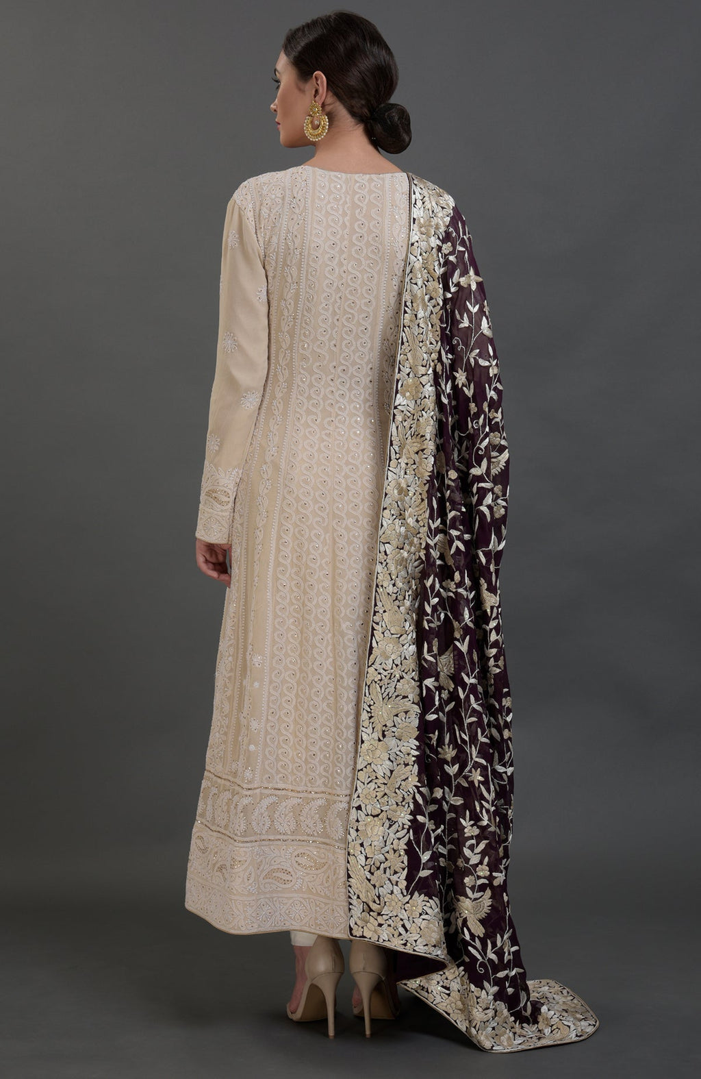 A woman models a champagne chikankari suit with a purple Parsi Gara embroidered dupatta.