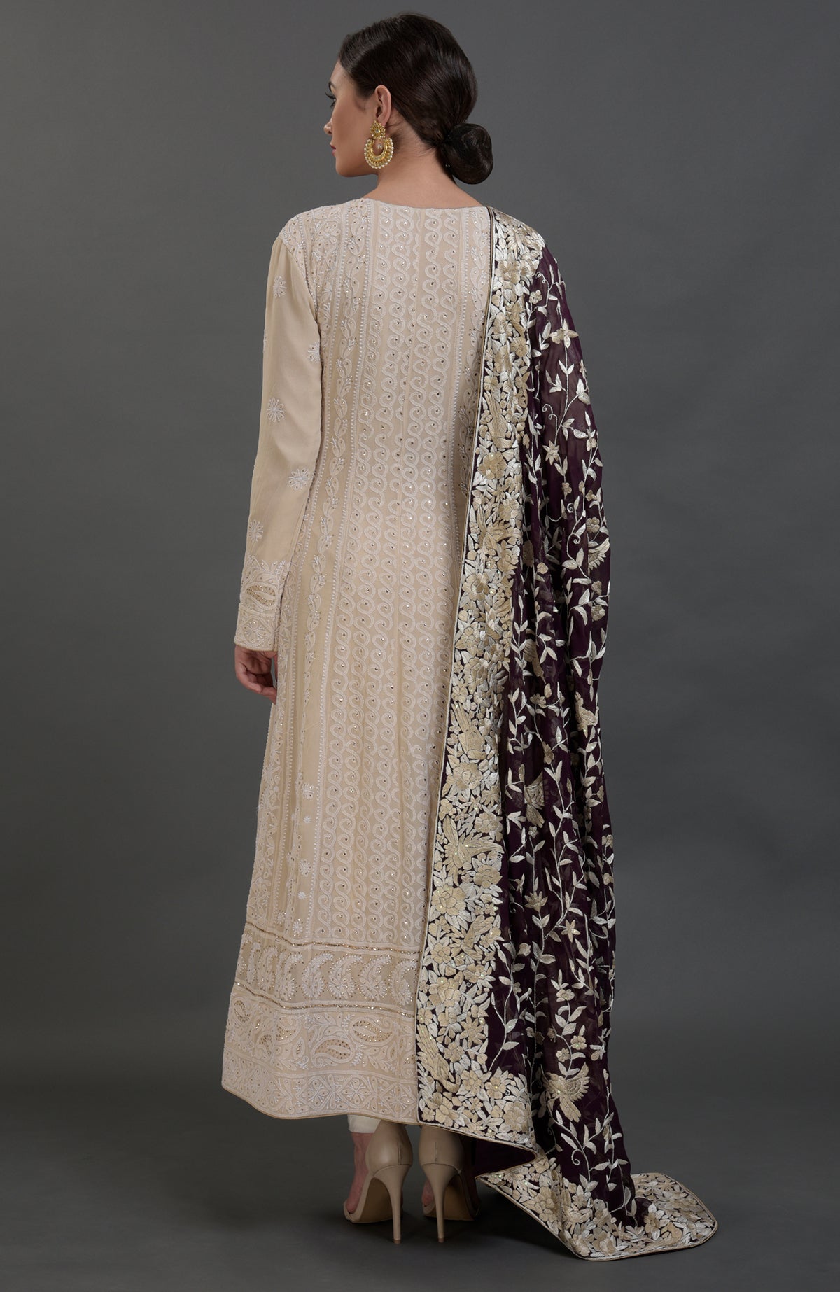 A woman models a champagne chikankari suit with a purple Parsi Gara embroidered dupatta.