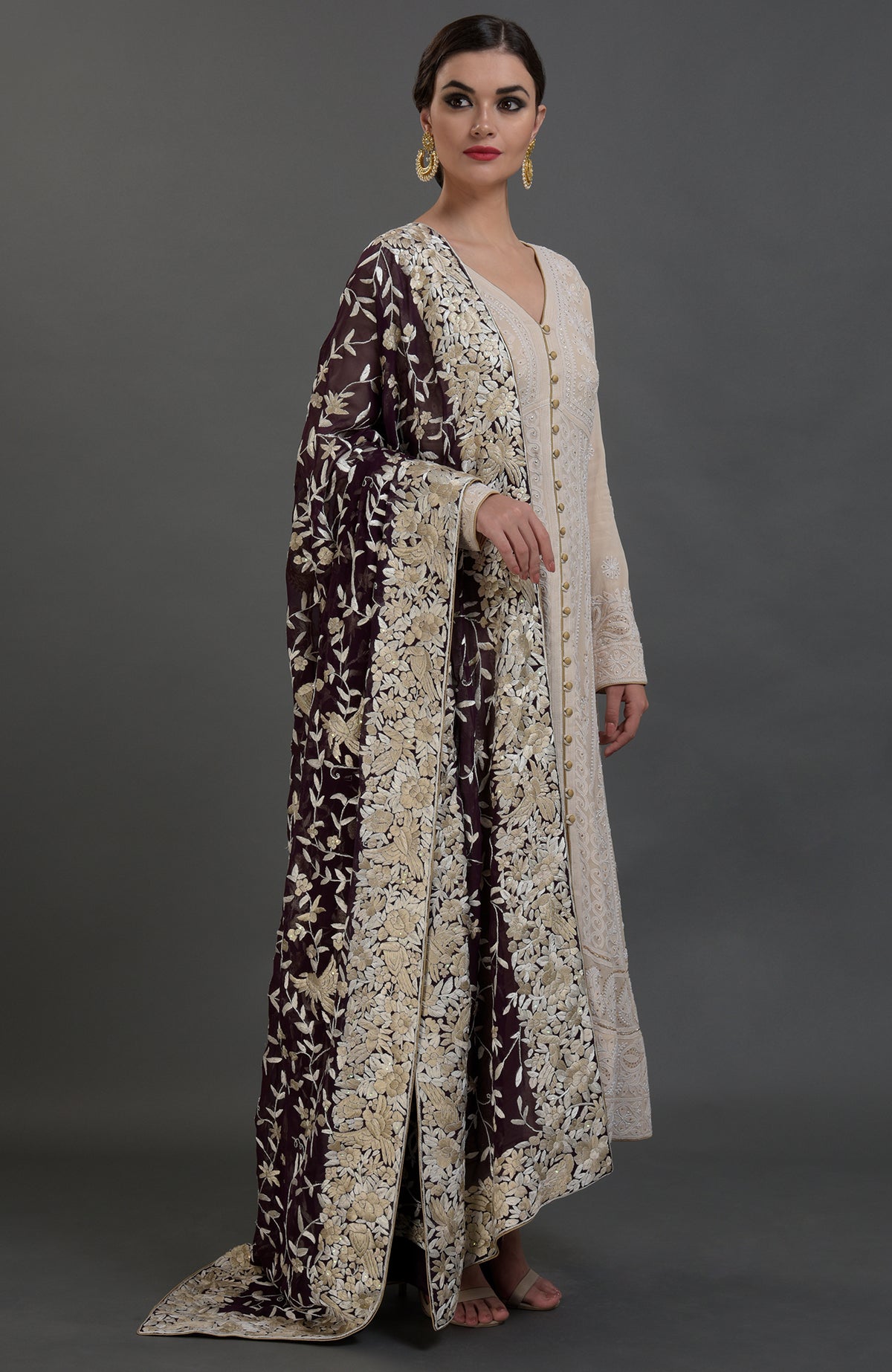 A woman models a champagne chikankari suit with a Parsi Gara hand-embroidered dupatta.