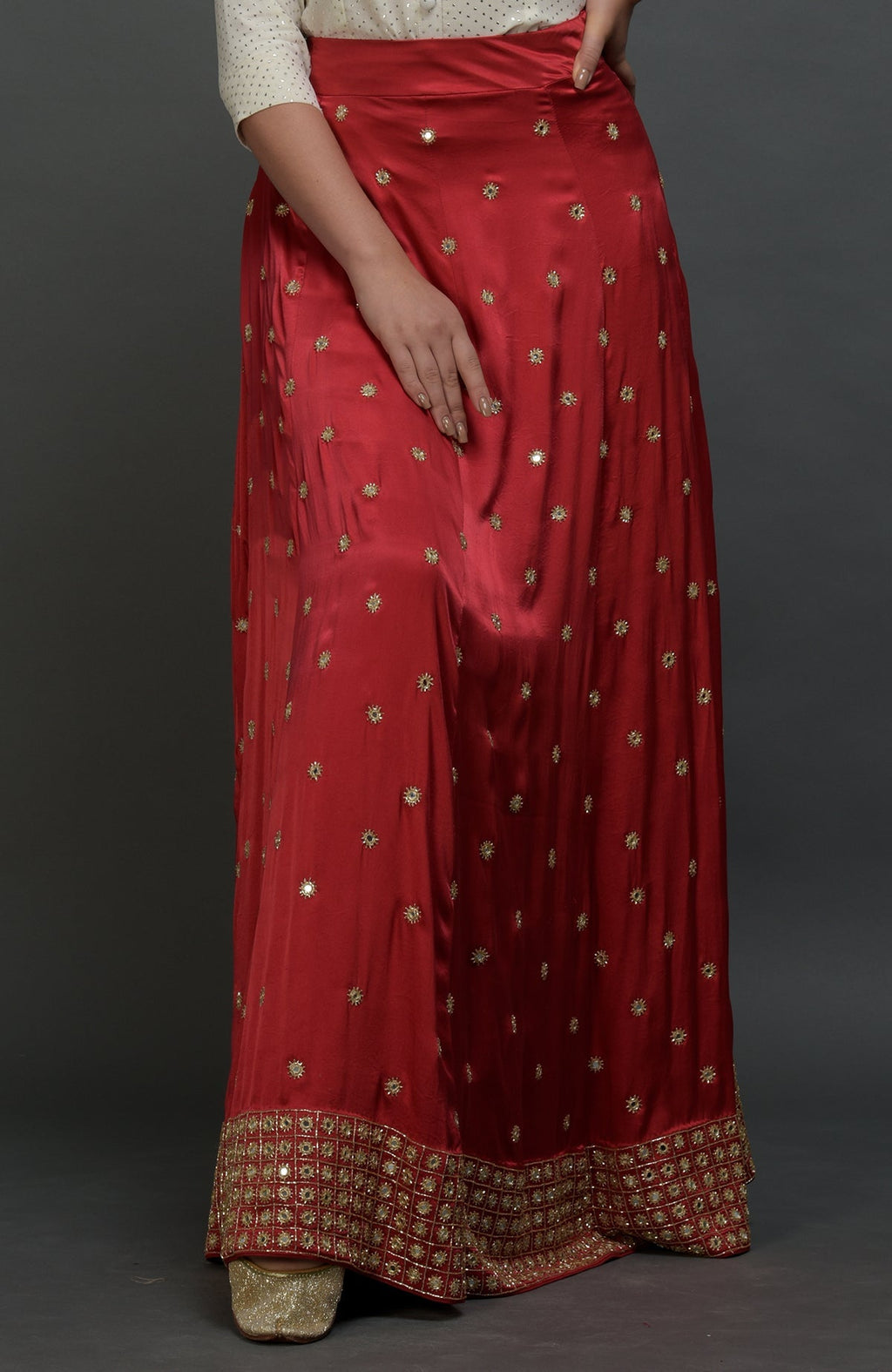 A model wears a royal red mirror work and zardozi skirt with a mukaish blouse.
