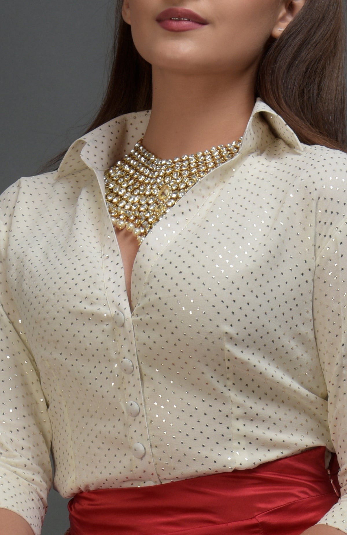 A woman wears a cream mukaish blouse with a gold and pearl choker necklace.
