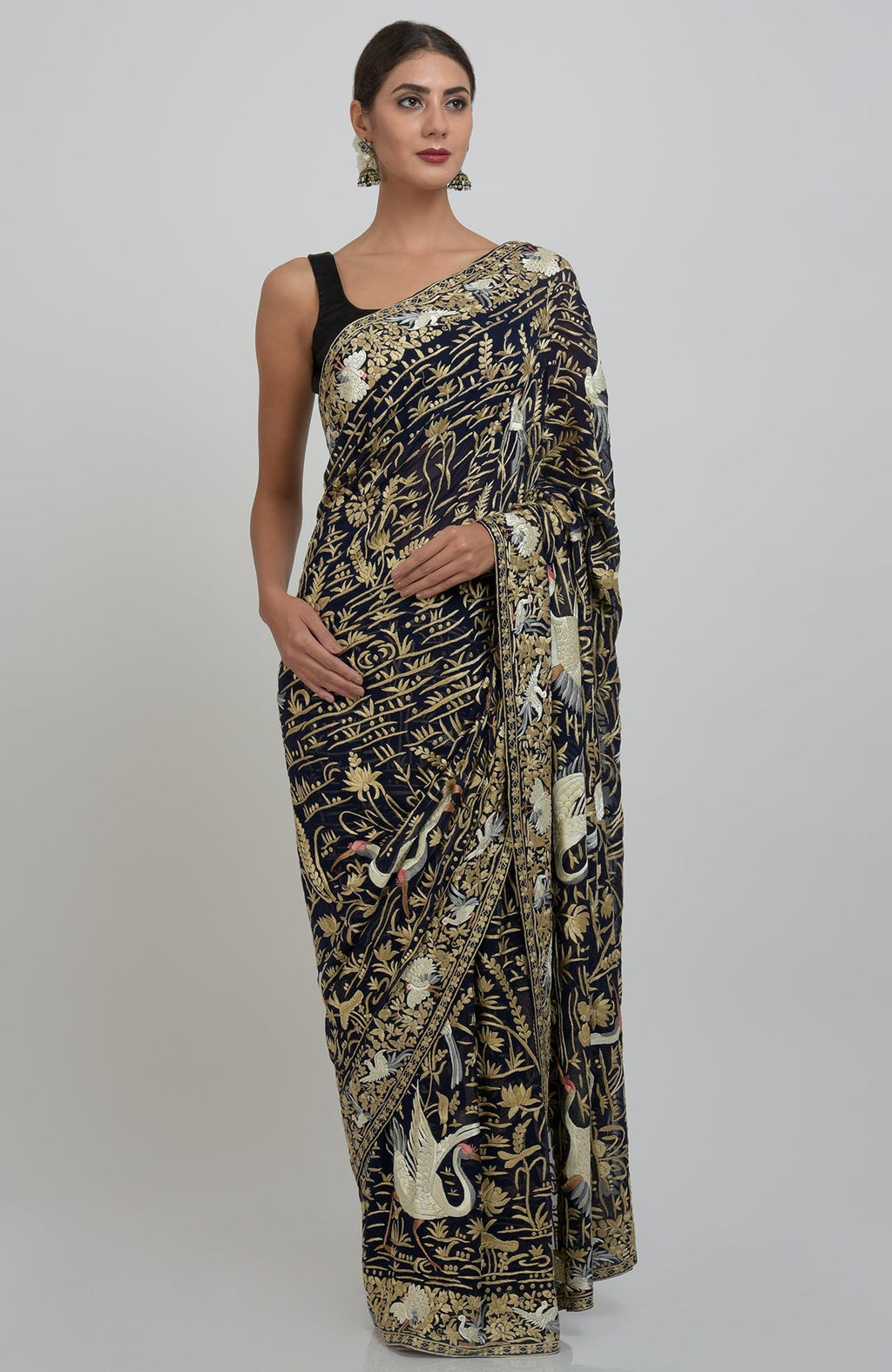 A woman models a midnight blue Parsi Gara hand-embroidered saree with crane and floral motifs.
