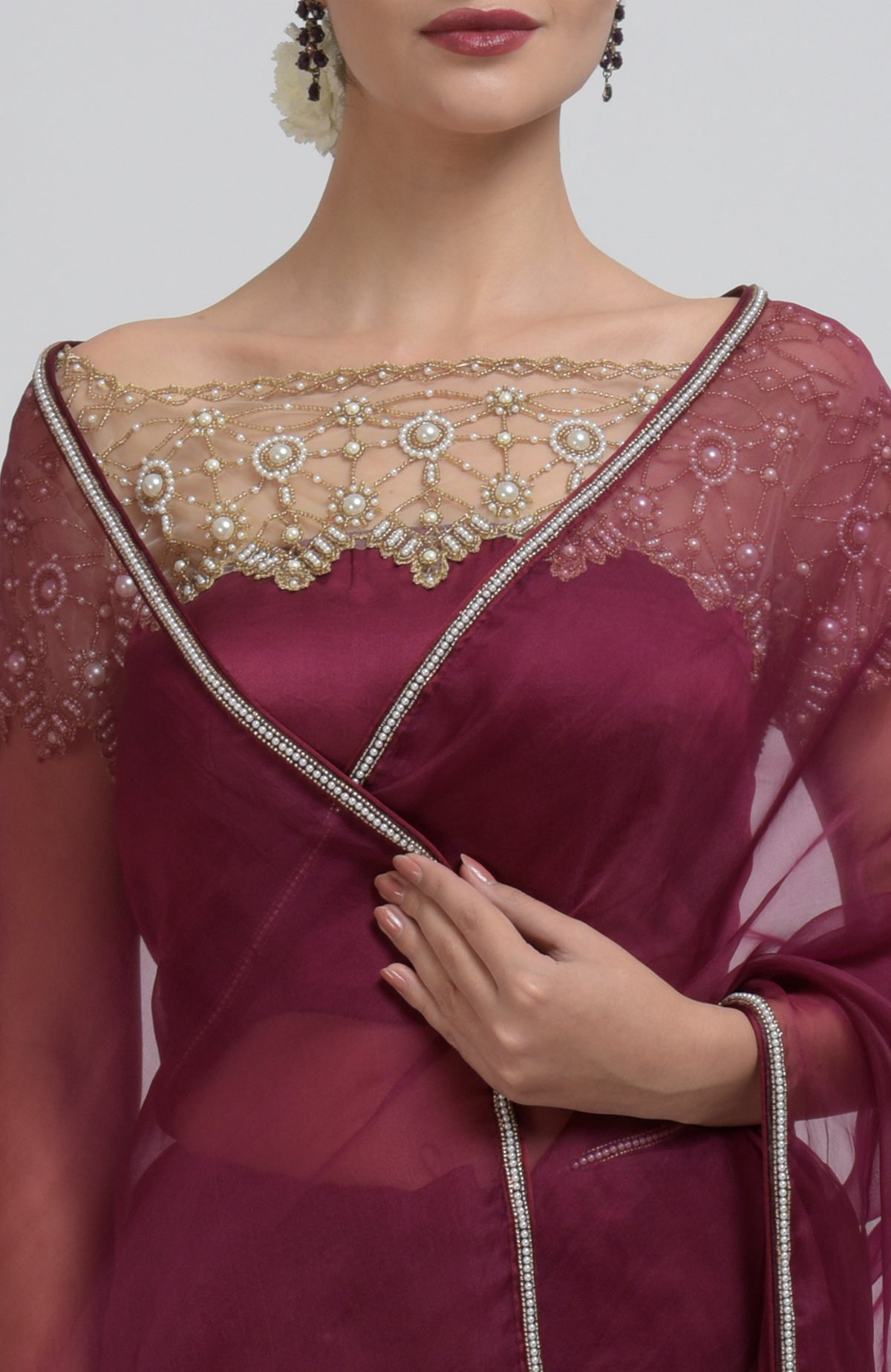 Burgundy organza silk saree with pearl bead embroidery and a matching blouse.