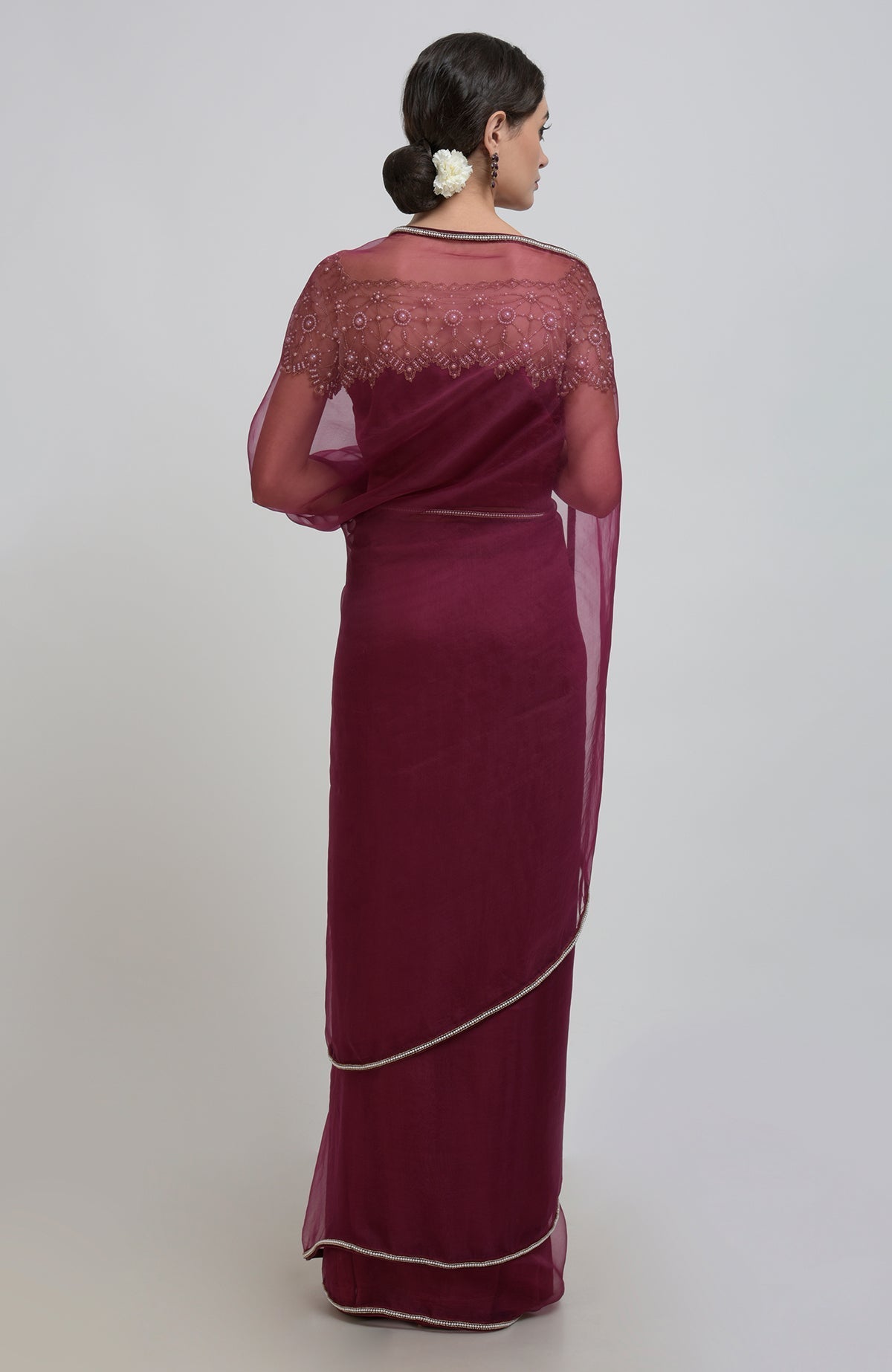 Burgundy organza silk saree with pearl bead embroidery and a matching blouse.