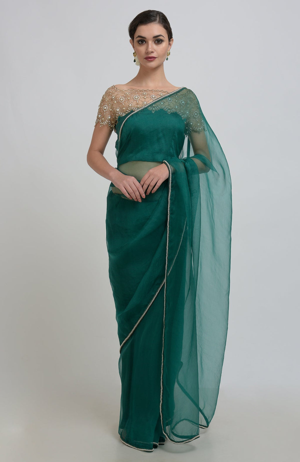 Emerald green organza saree with pearl bead embroidery and a matching blouse.