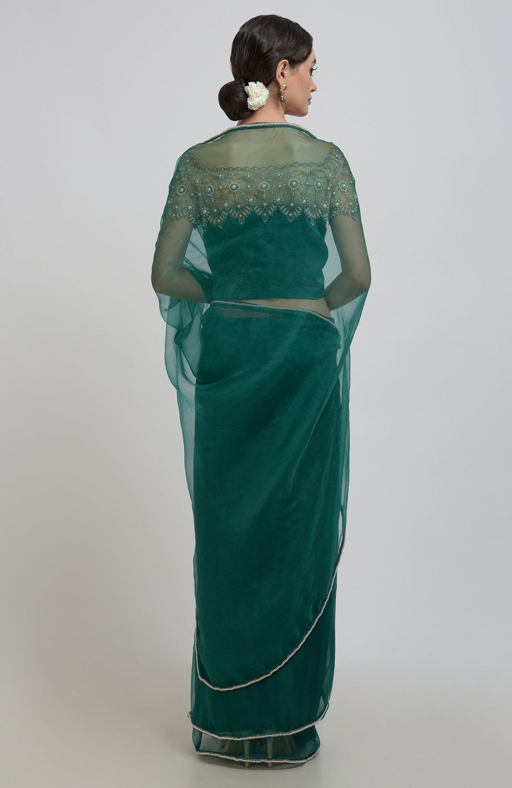 Emerald green pearl beads hand embroidered saree and blouse on a model.