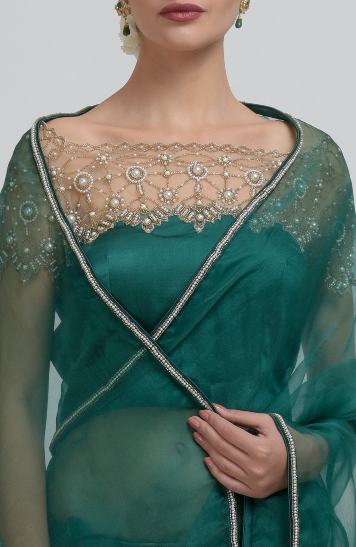Emerald green saree with pearl bead embroidery and a sheer blouse.