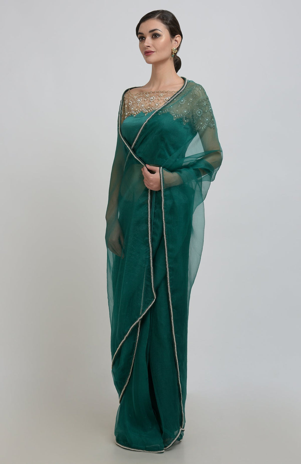 Emerald green organza silk saree with pearl bead embroidery and a matching blouse.