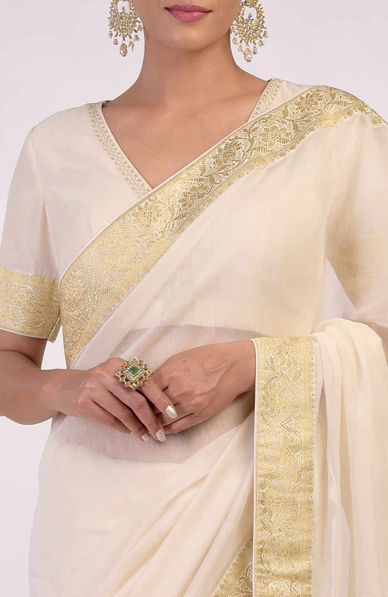 Ivory saree with gold Banarasi border and motifs, paired with embroidered blouse with V-neck.