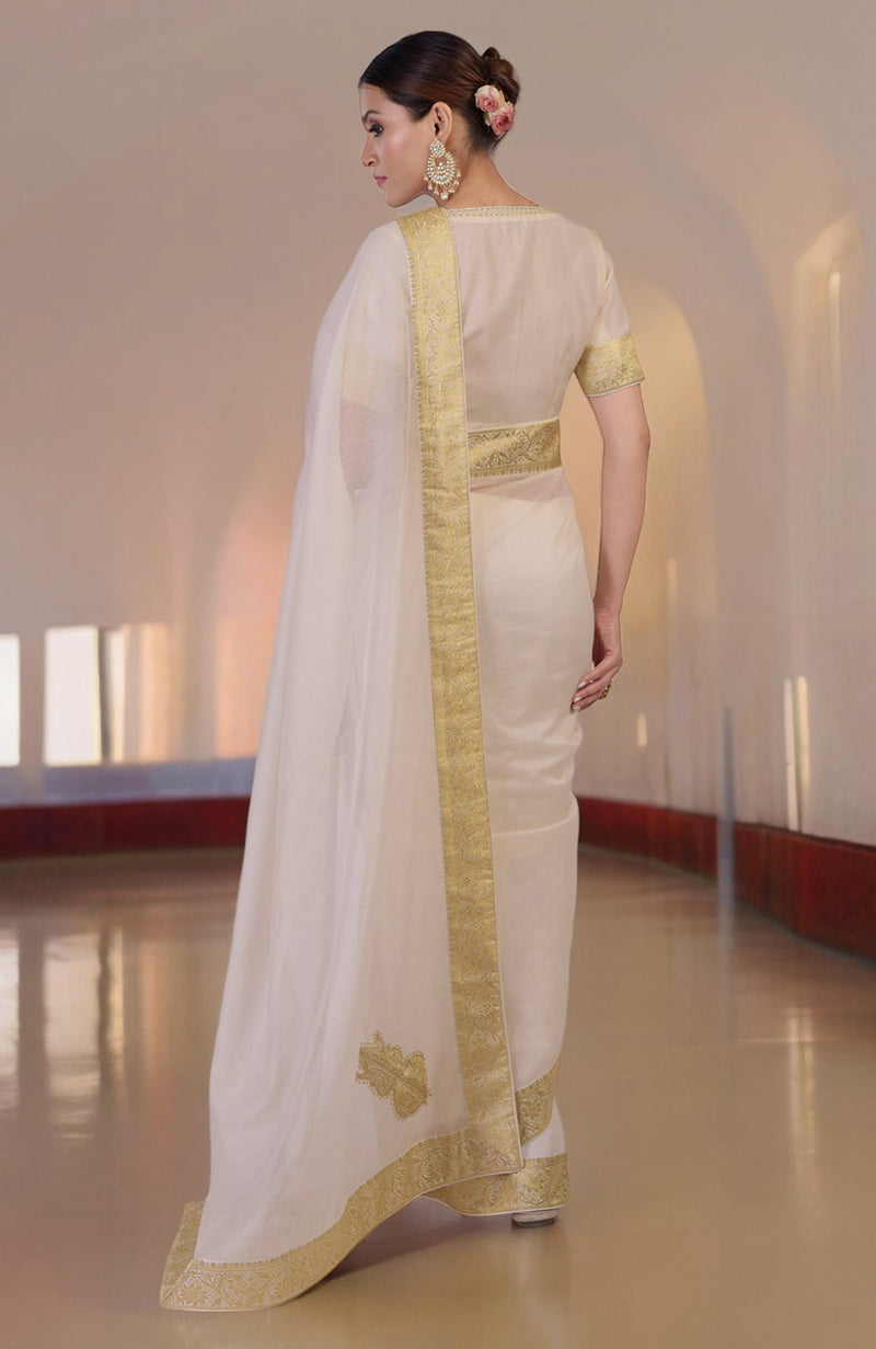 Ivory saree with gold Banarasi border and motifs, paired with embroidered blouse with V-neck.
