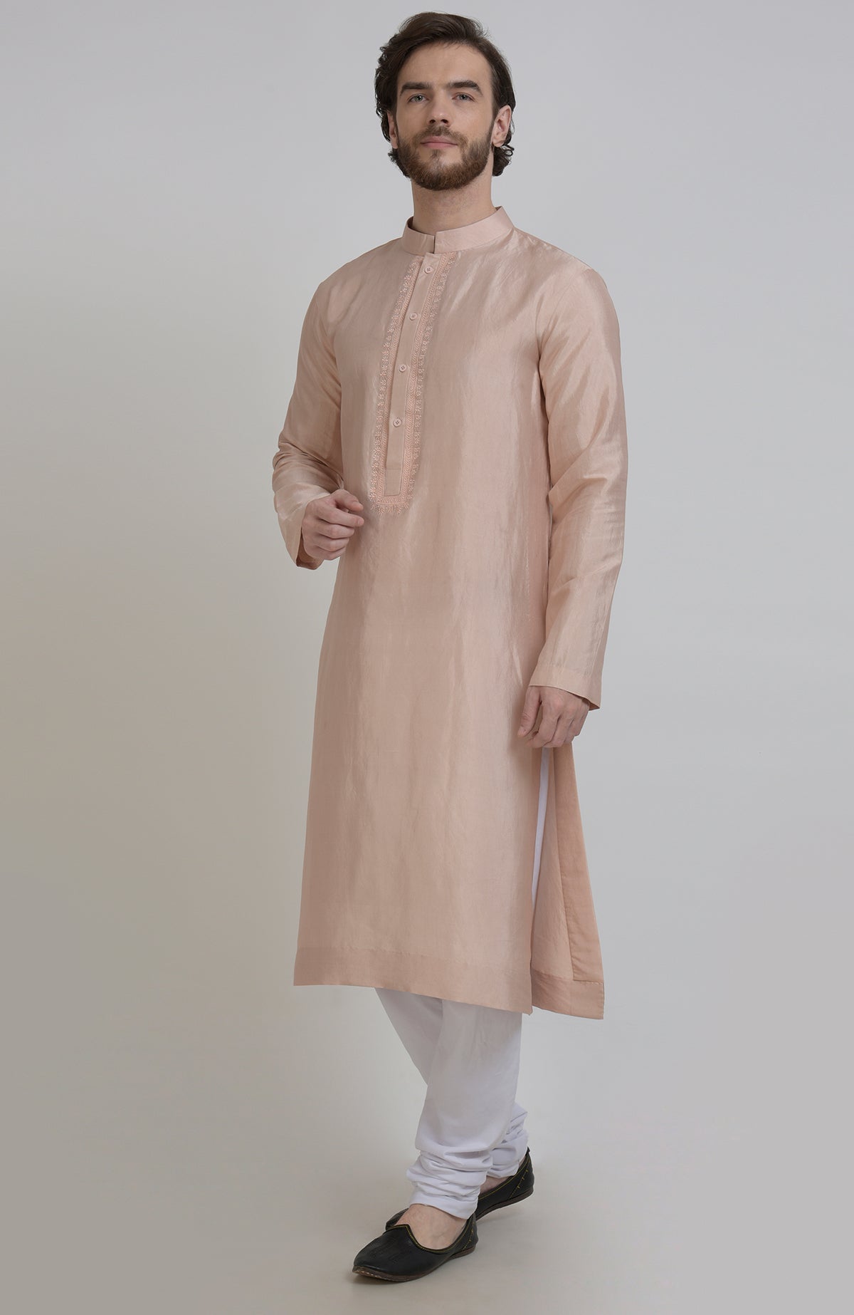 An oyster pink silk kurta with an embroidered placket, paired with white churidar pants.