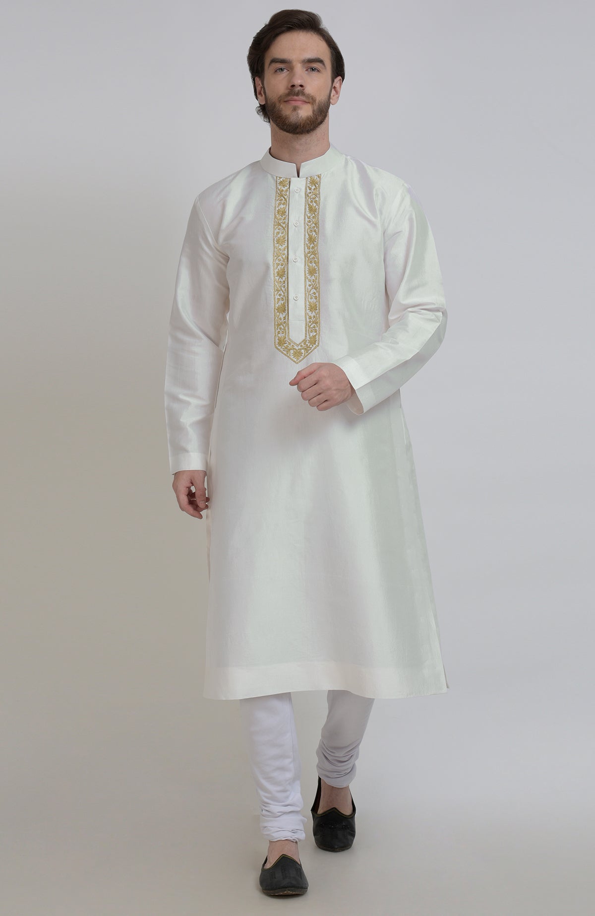 Ivory silk kurta with gold tilla embroidered placket, paired with white churidar and black shoes.