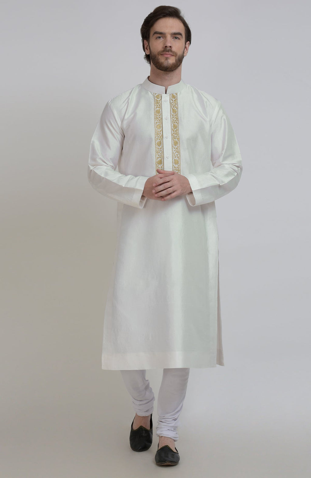 An ivory silk kurta with gold tilla embroidered placket detail, worn by a man.