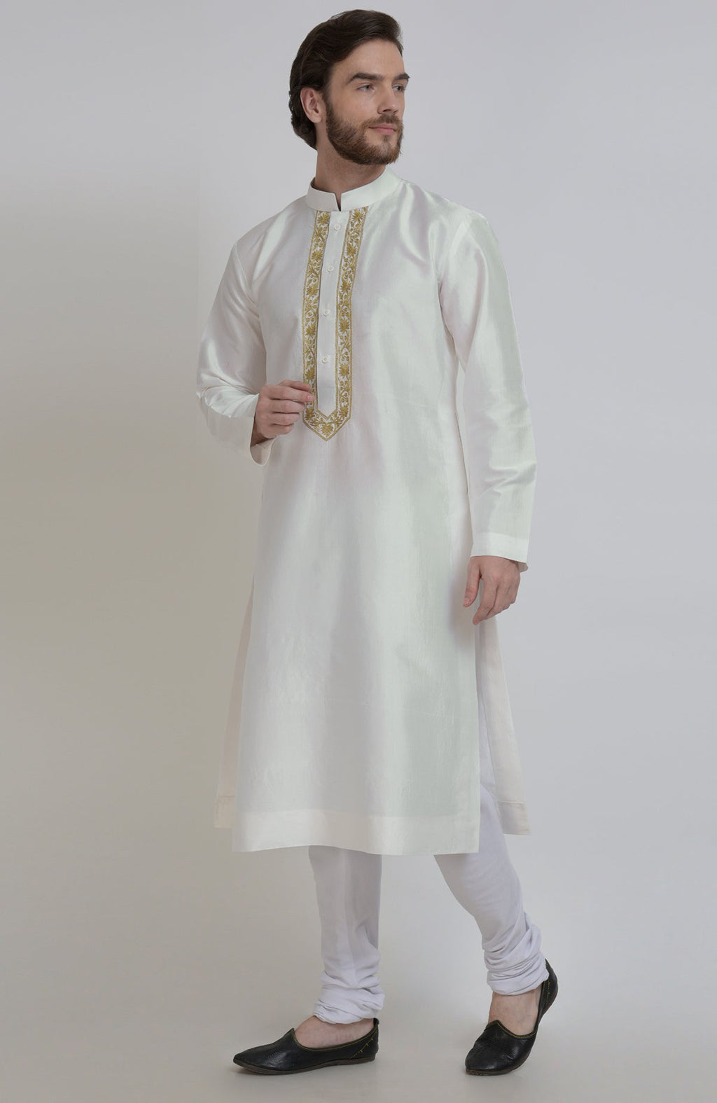 An ivory silk kurta with gold tilla embroidery on the placket, paired with white churidar.