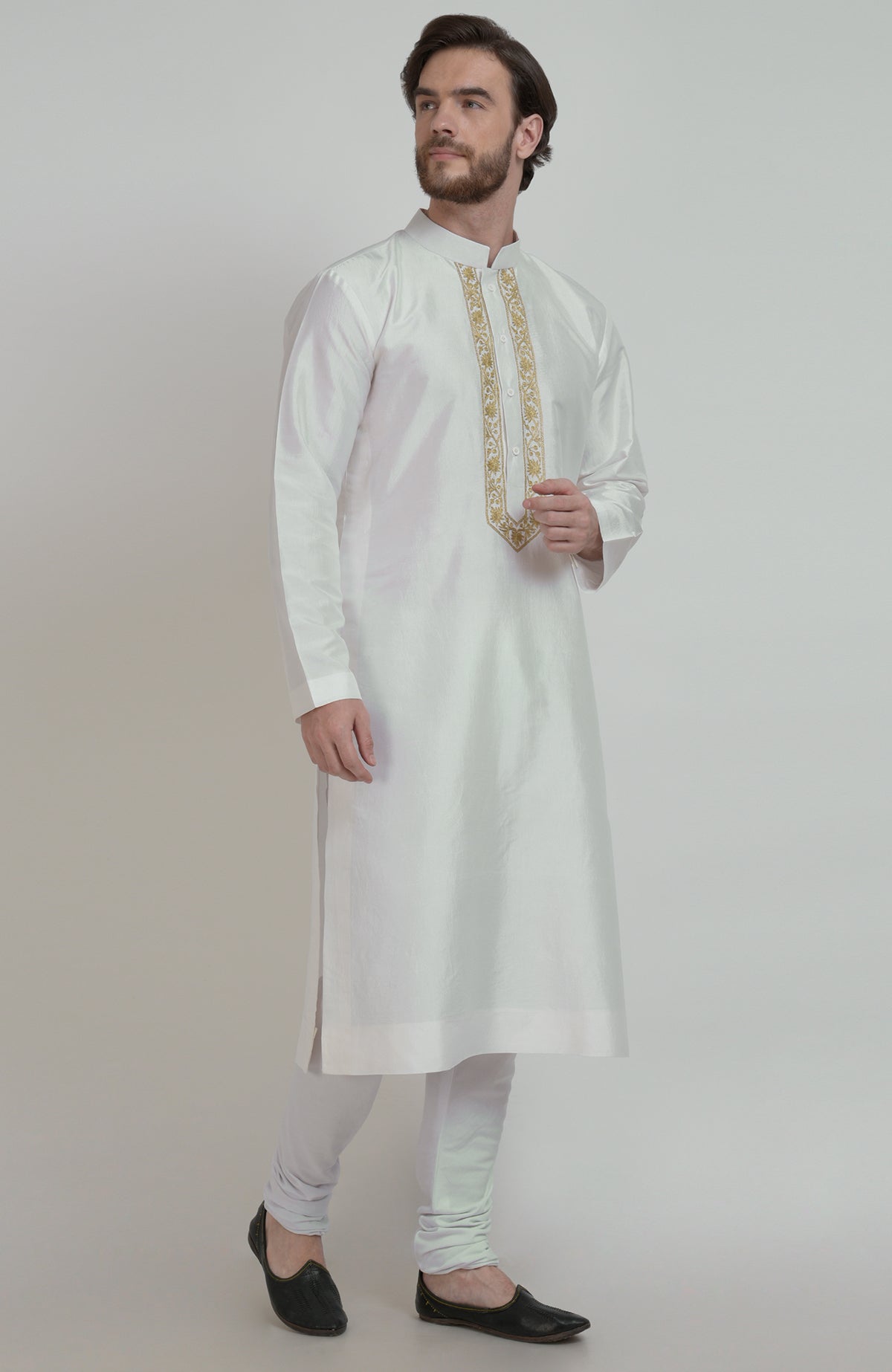 Ivory silk kurta with gold tilla embroidered placket, paired with white churidar and black shoes.