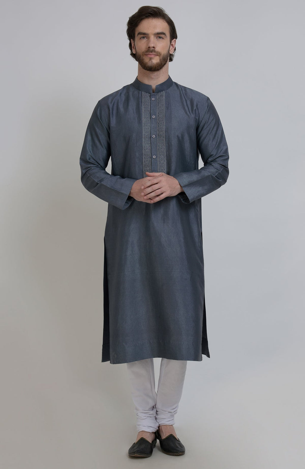 A man models a grey silk kurta with an embroidered placket and white churidar pants.
