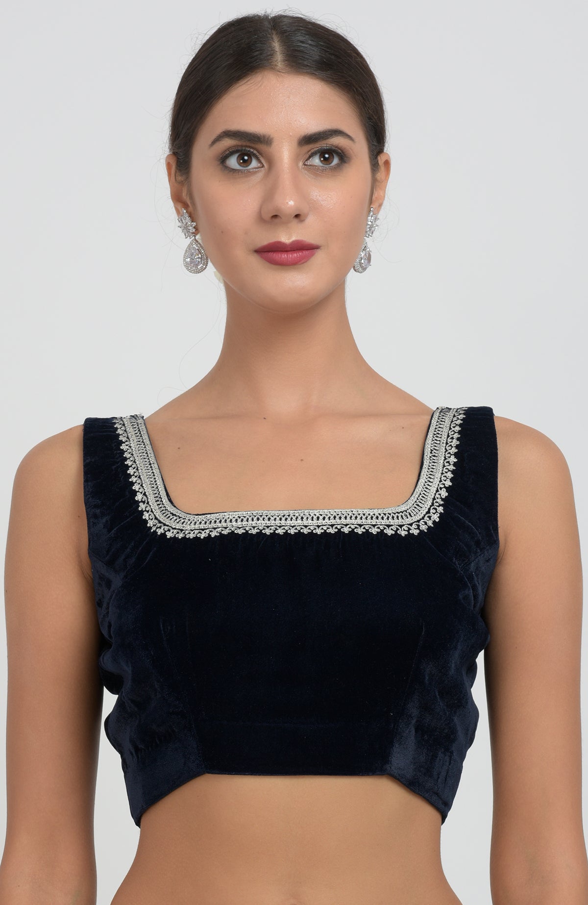 A woman models a midnight blue velvet saree with silver tilla aari embroidery.
