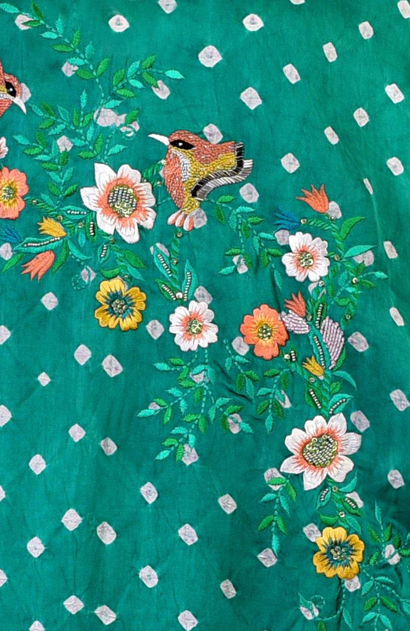Emerald green bandhej fabric with colorful bird and floral embroidery.