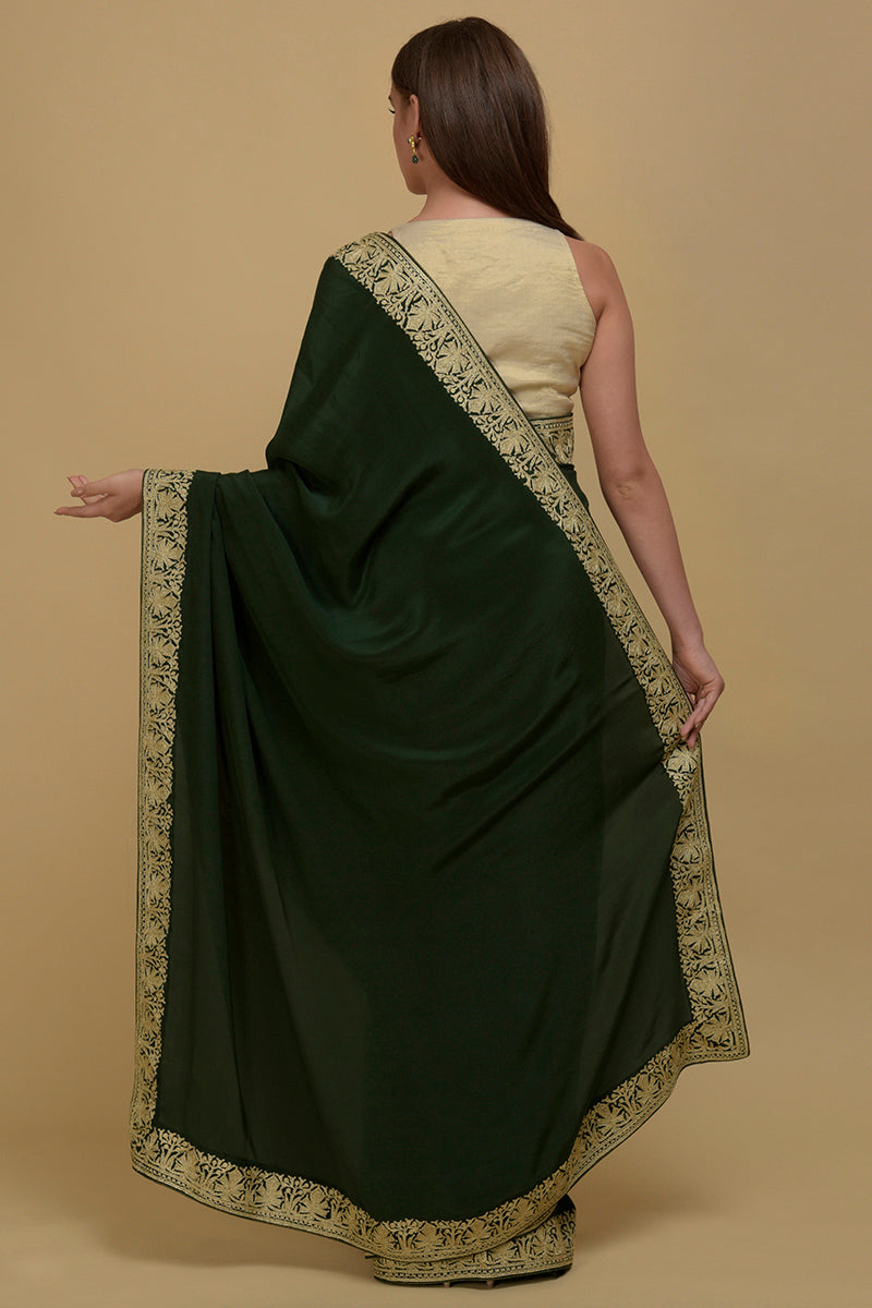 Bottle green pure crepe saree with gold Kashmiri tilla aari embroidered borders.