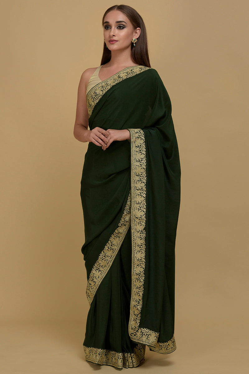 Bottle green pure crepe saree with gold Kashmiri tilla aari embroidered borders.