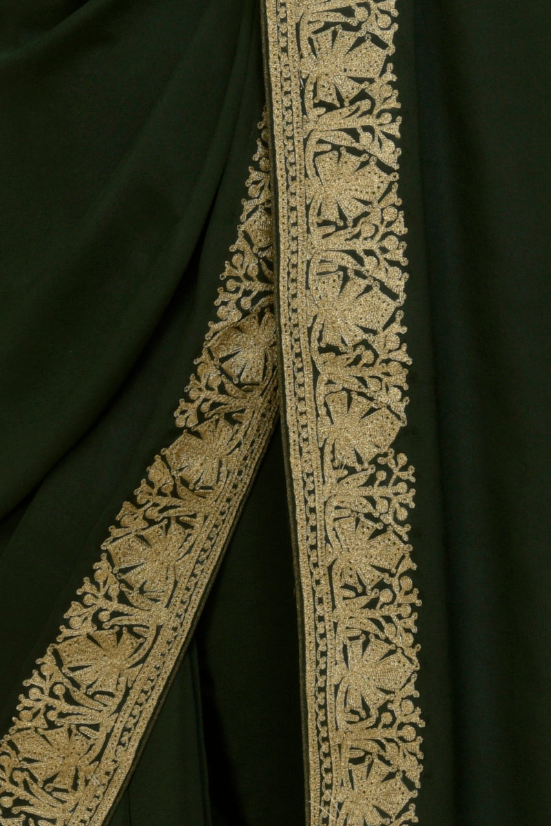 Bottle green pure crepe saree with intricate gold tilla aari embroidered borders.