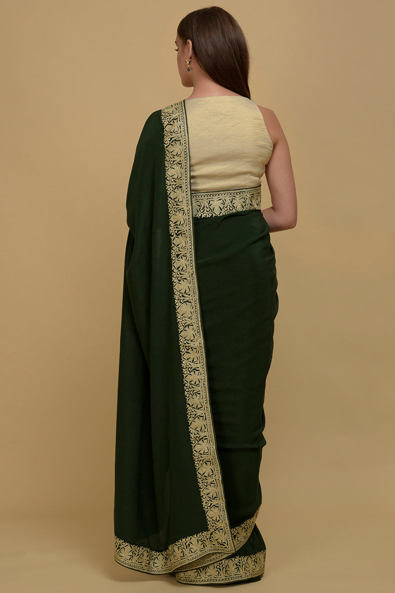 Bottle green pure crepe saree with gold Kashmiri tilla aari embroidered borders.