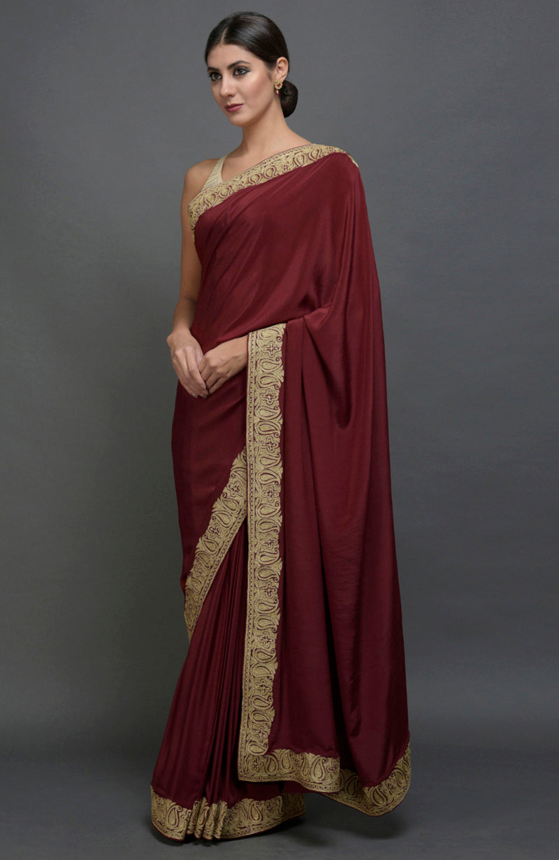 Maroon pure crepe saree with gold paisley tilla aari embroidered borders.