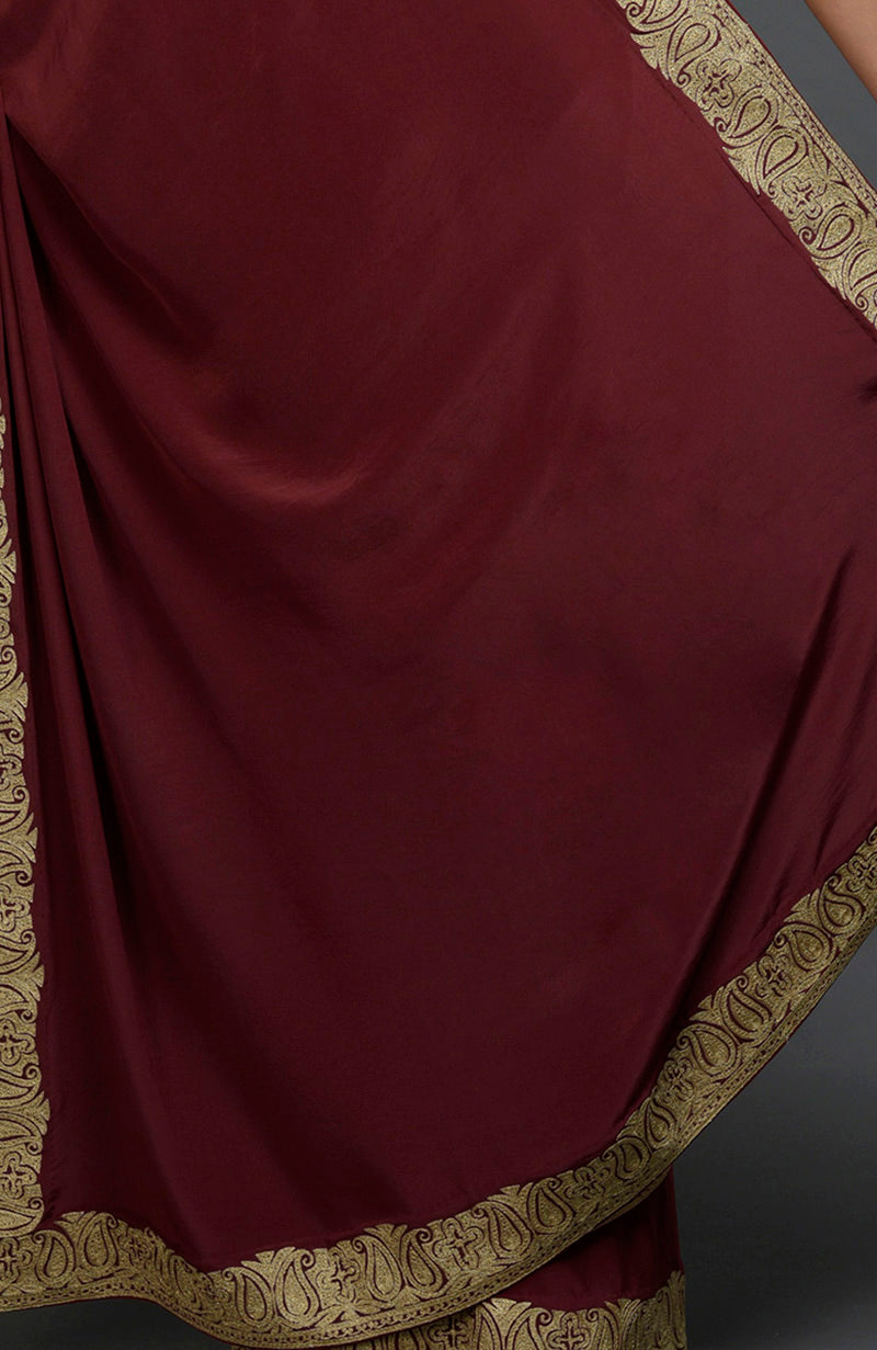 Maroon pure crepe saree with gold paisley tilla aari embroidered borders.
