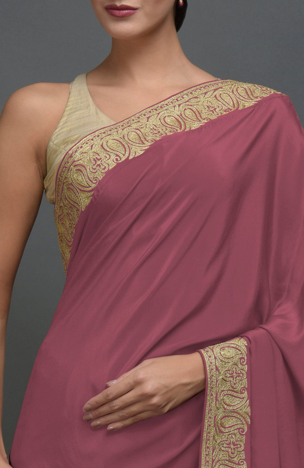 A woman models a China rose pure crepe saree with gold Kashmiri tilla aari embroidery.