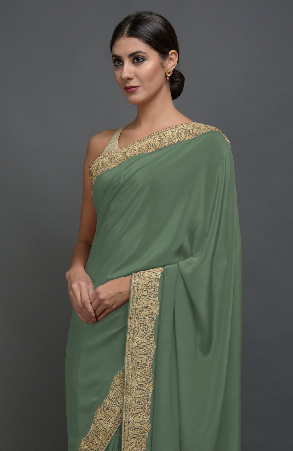 Dark jade pure crepe saree with gold paisley tilla aari embroidered borders.