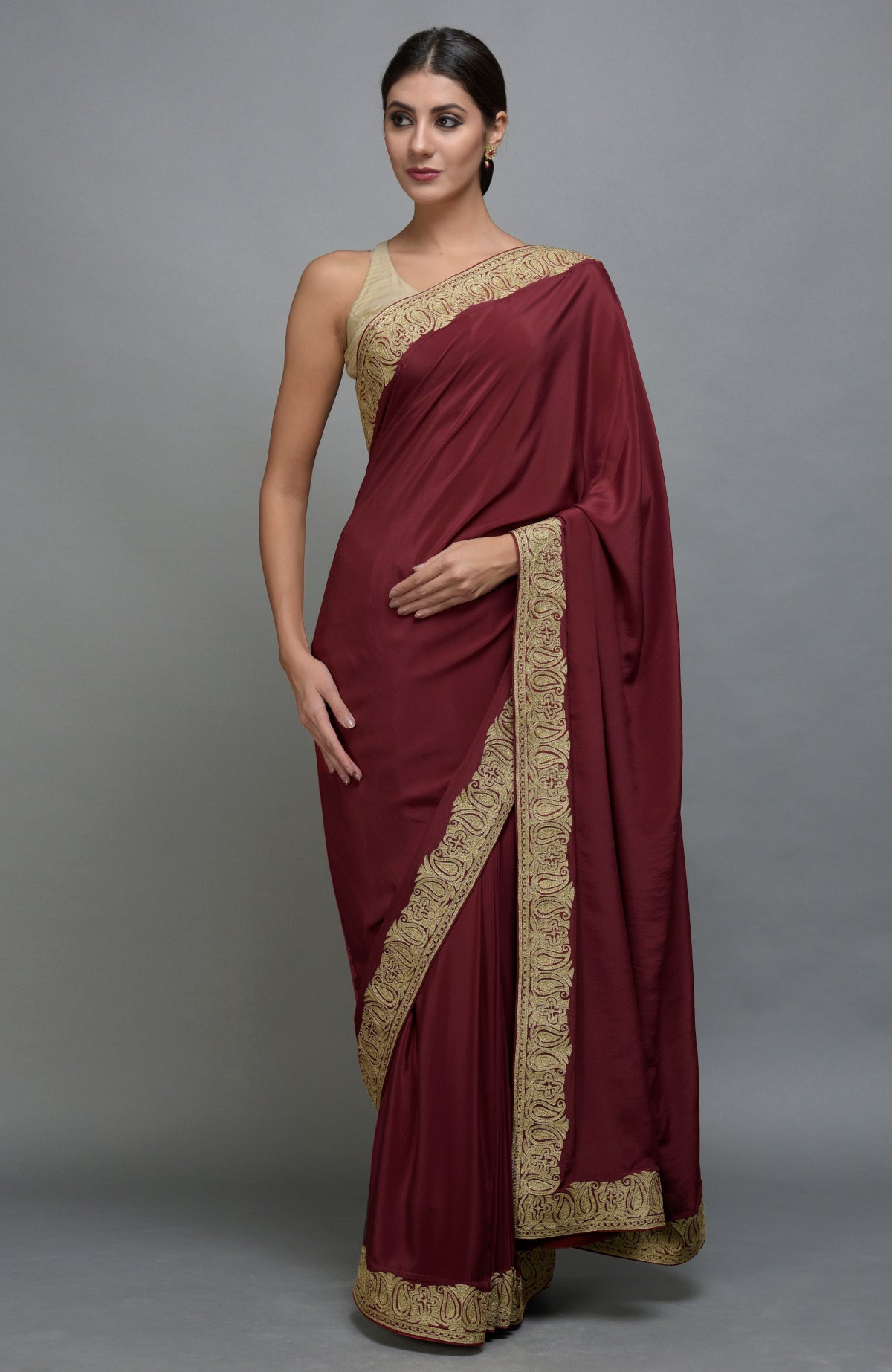 Maroon pure crepe saree with gold paisley tilla aari embroidered borders.