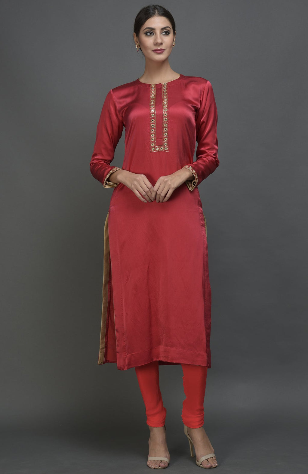 A woman models a red satin silk suit with mirror and zardozi embroidery.
