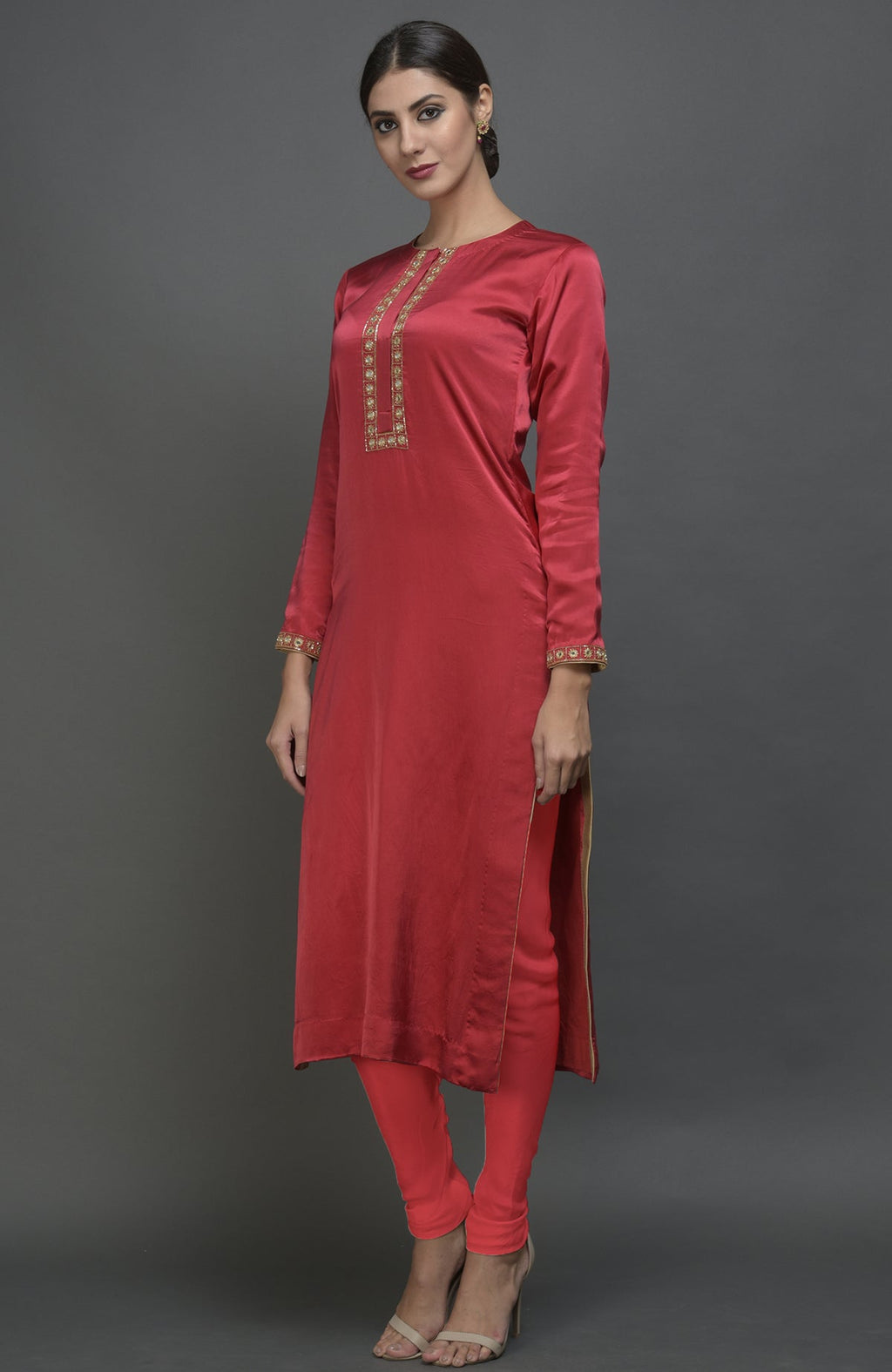 A woman models a red satin silk suit with gold embroidery and matching leggings.