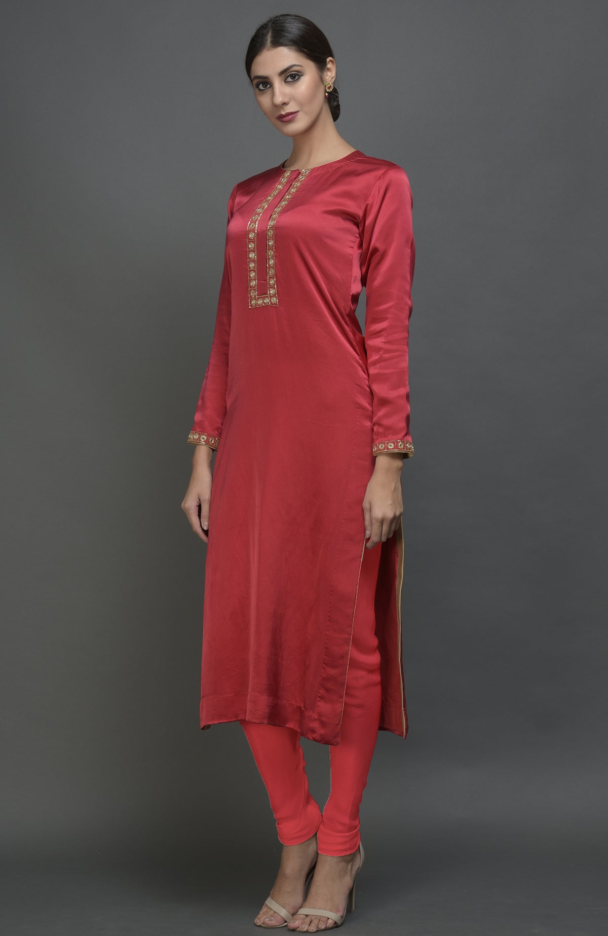 A woman models a red satin silk suit with gold embroidery and matching leggings.