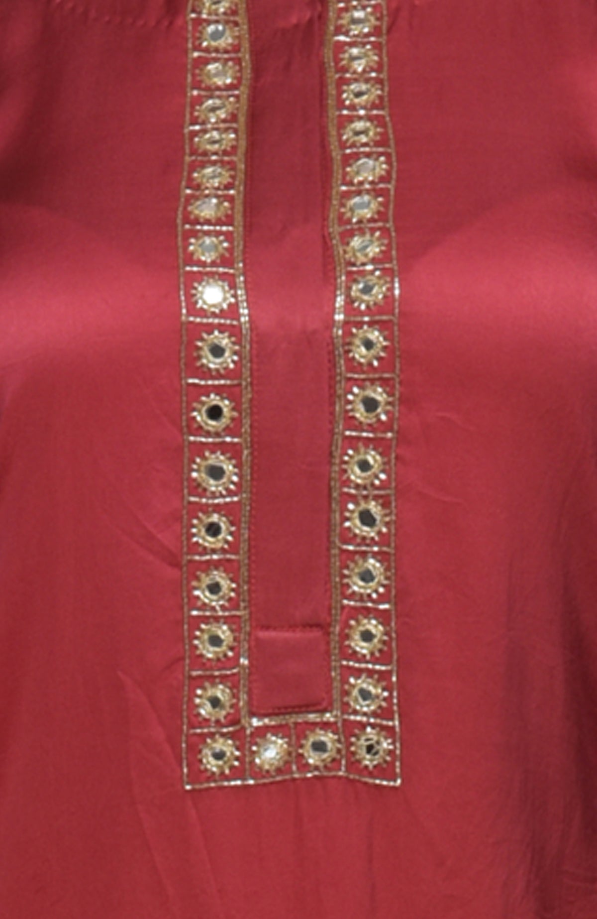 A close-up of a red suit with gold mirror and zardozi embroidery.