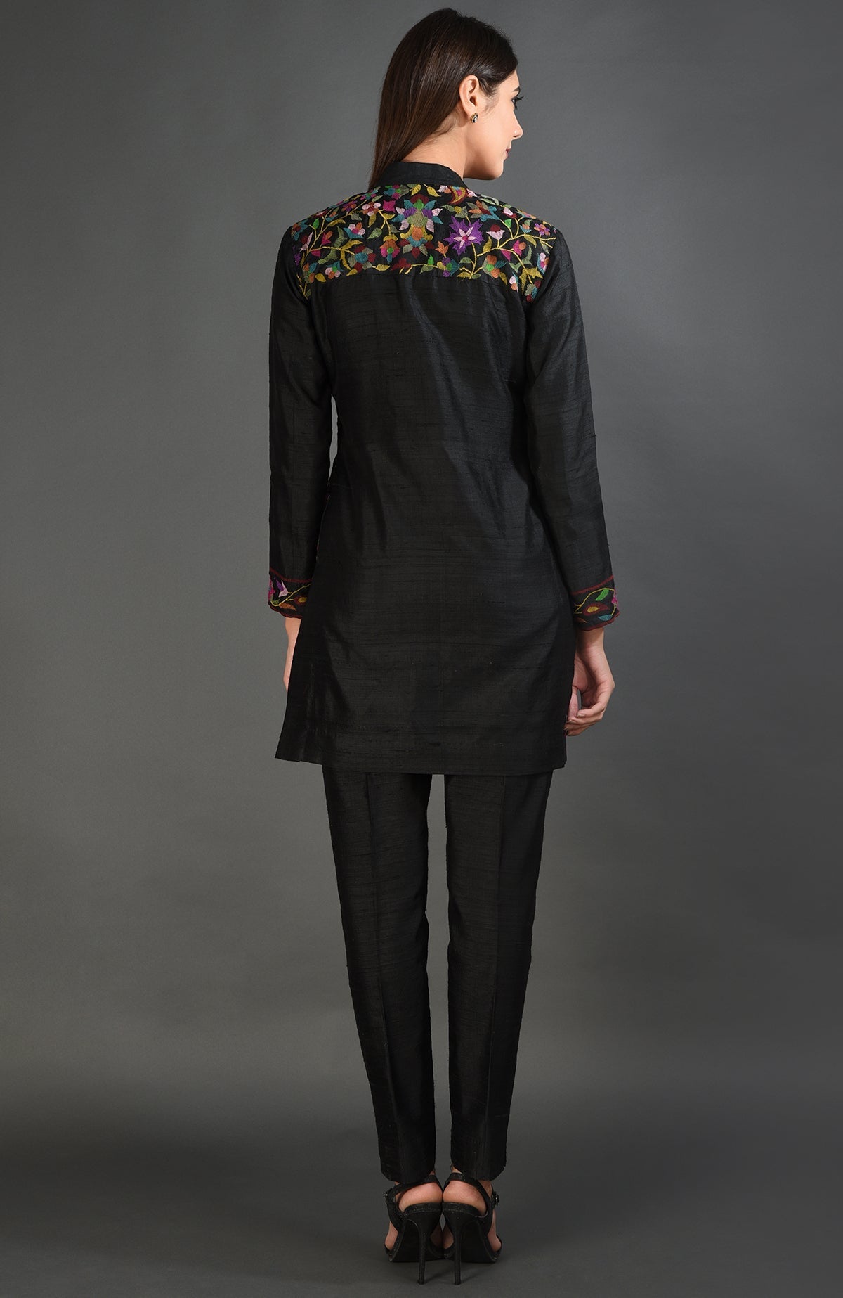 Black raw silk jacket with colorful floral embroidery on the back yoke and sleeve ends.