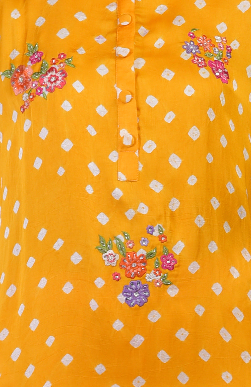 Turmeric yellow bandhej co-ord set with floral embroidery and white polka dots.