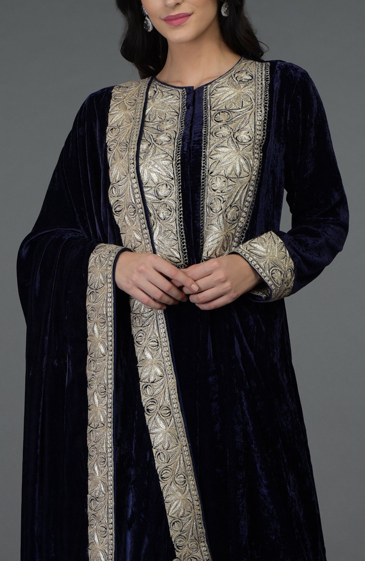 A woman models a midnight blue velvet suit with silver tilla embroidery.