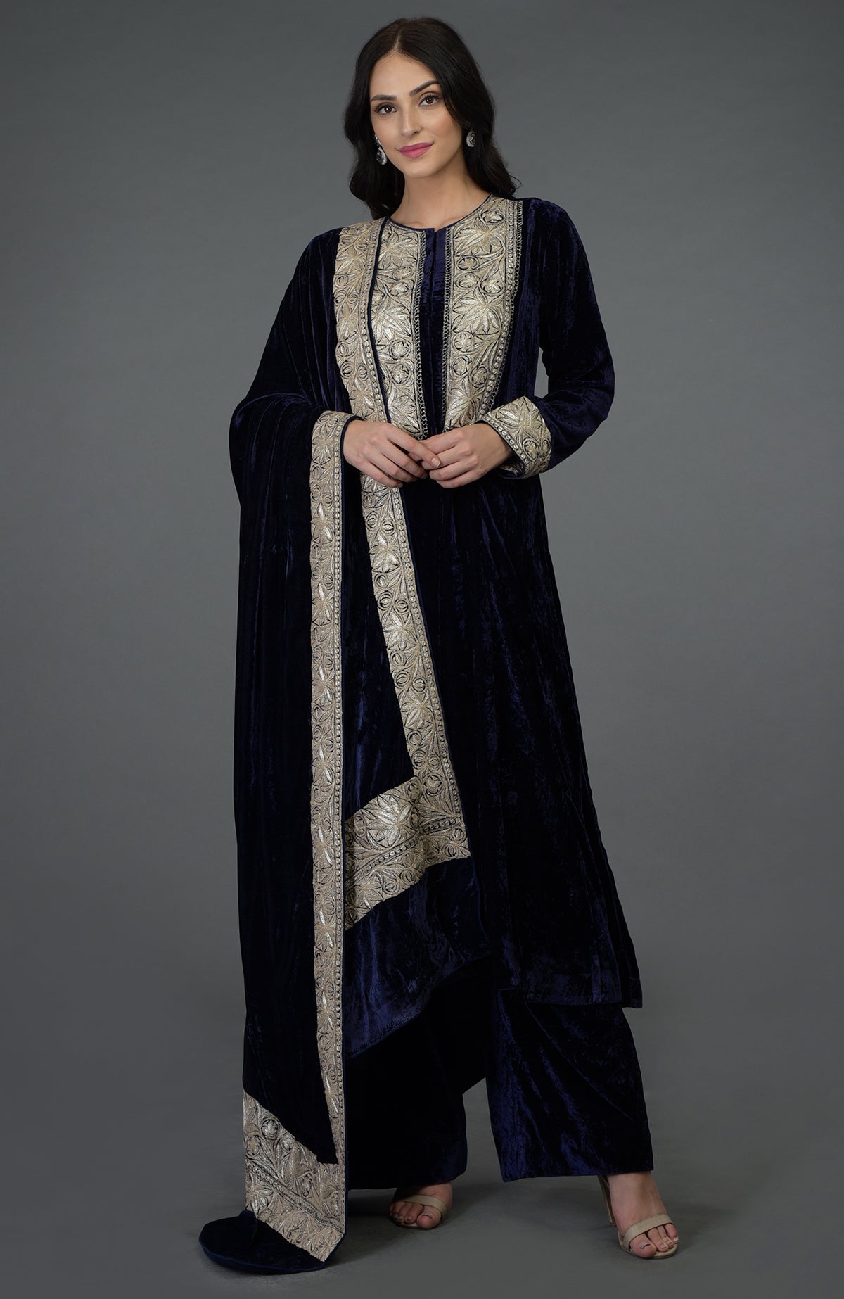 A woman models a midnight blue silk-velvet suit with silver Tilla embroidery.