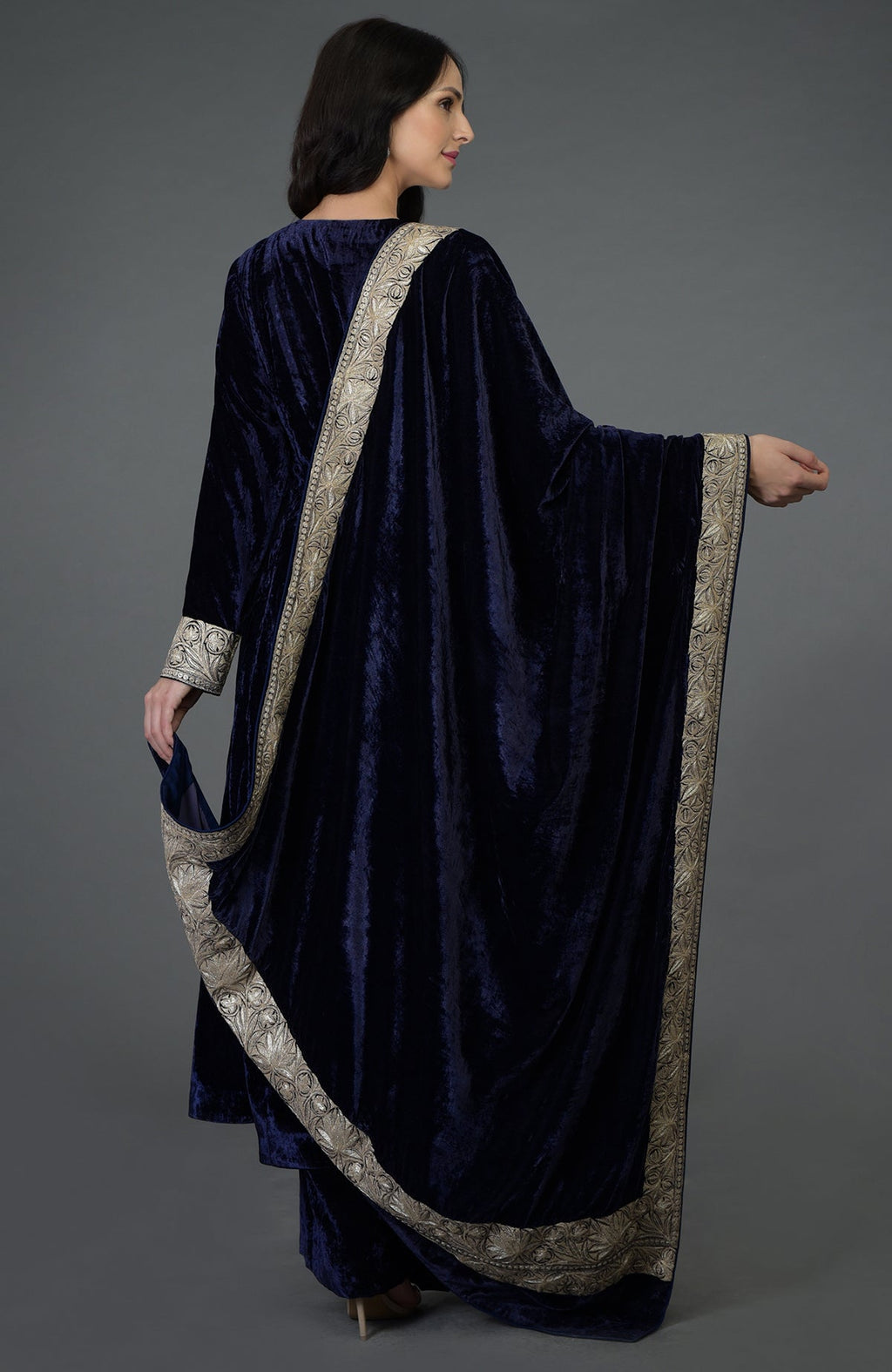 Woman in a midnight blue velvet suit with silver embroidery on the sleeves and dupatta.
