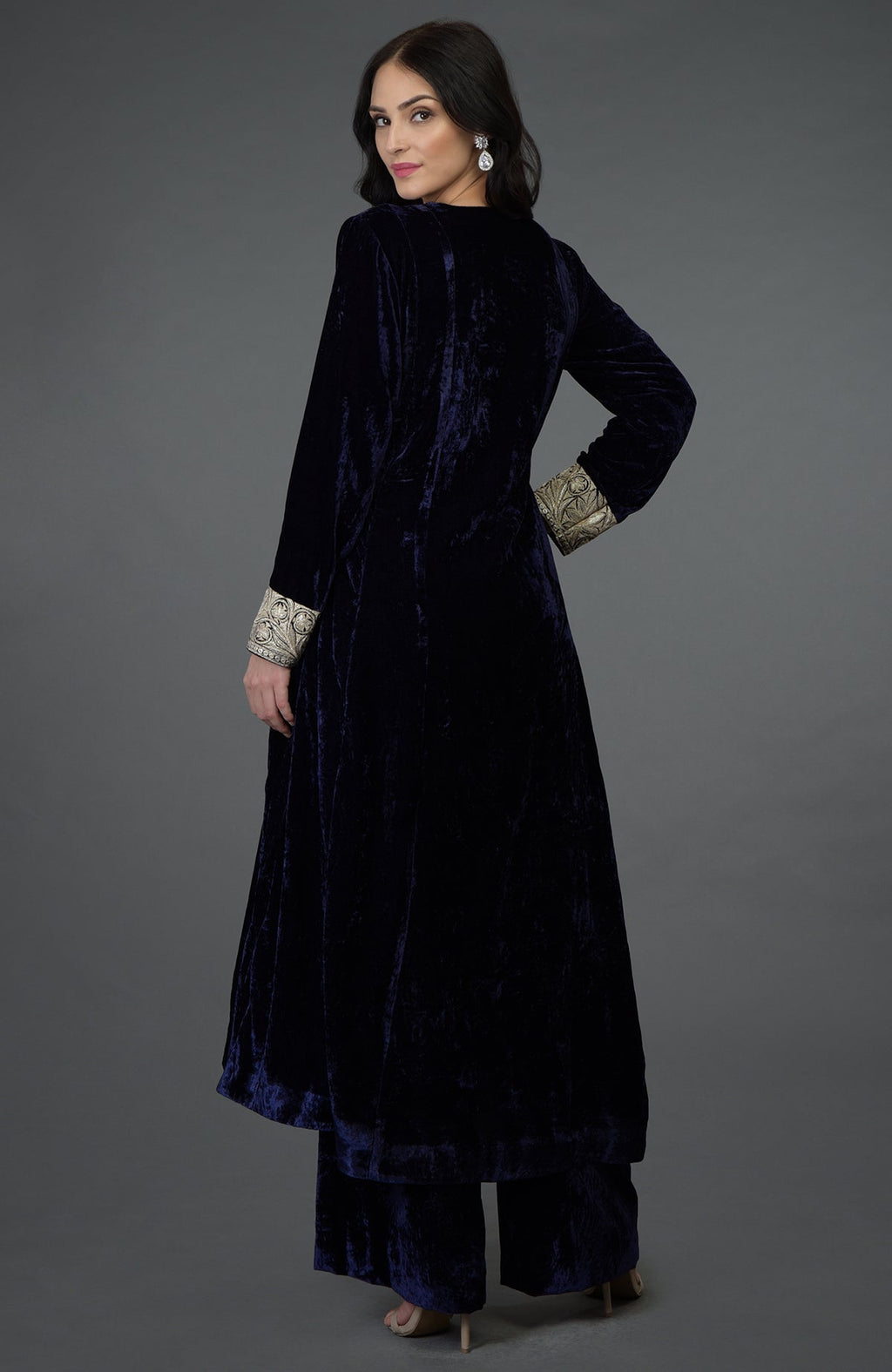 A woman models a midnight blue velvet suit with silver tilla embroidery.