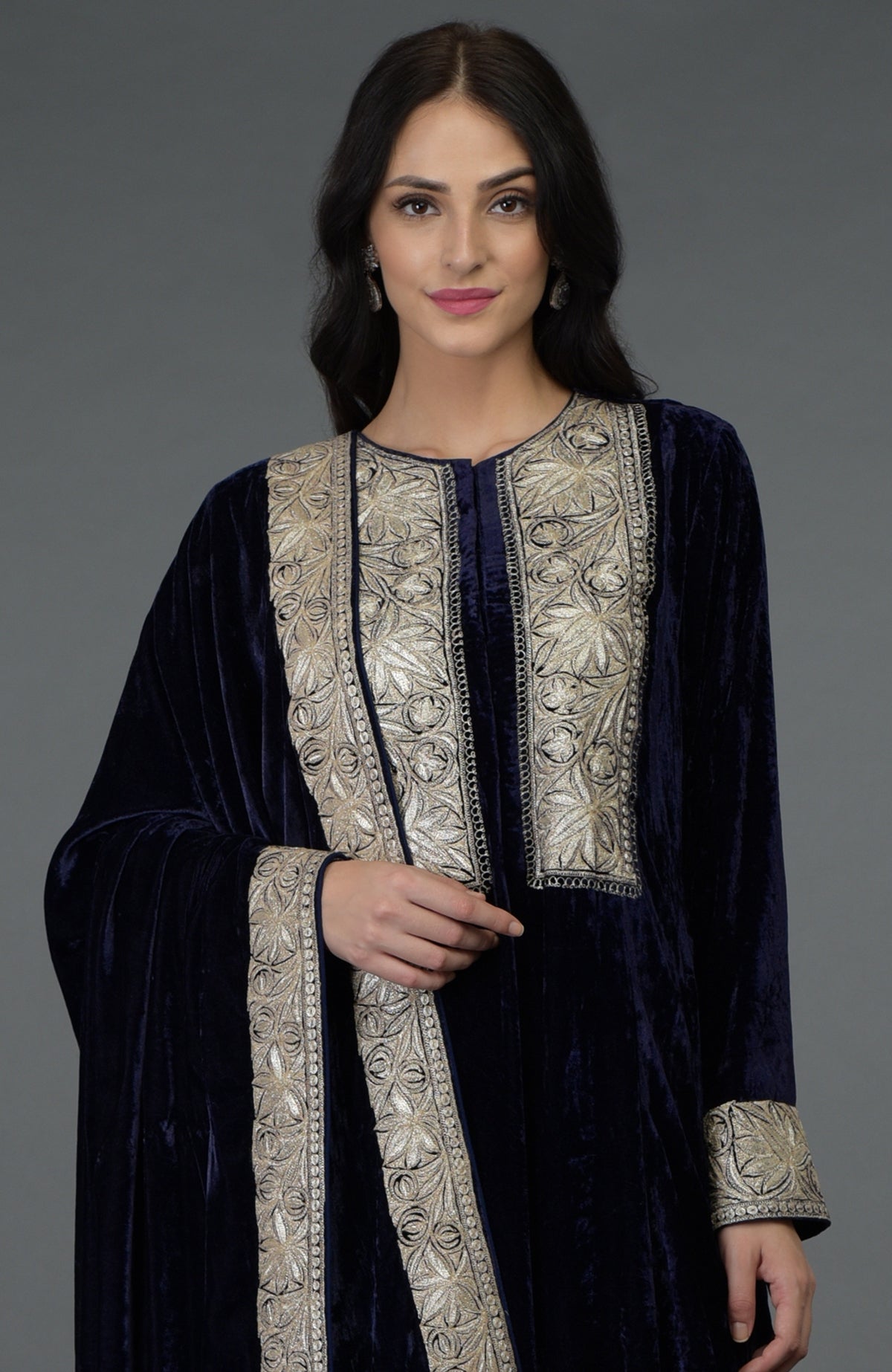 A woman models a midnight blue silk-velvet suit with silver Tilla embroidery.