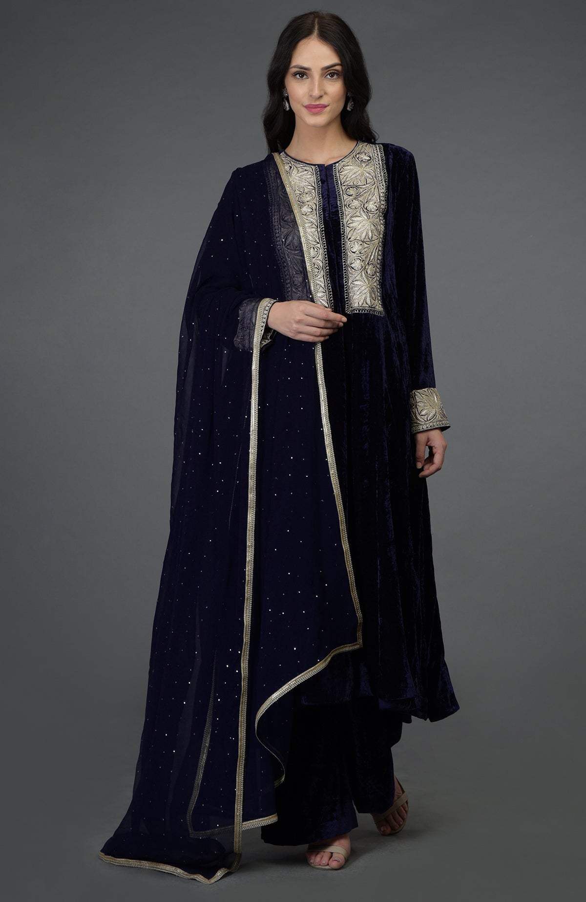 A woman models a midnight blue silk-velvet suit with Kashmiri Tilla embroidery.