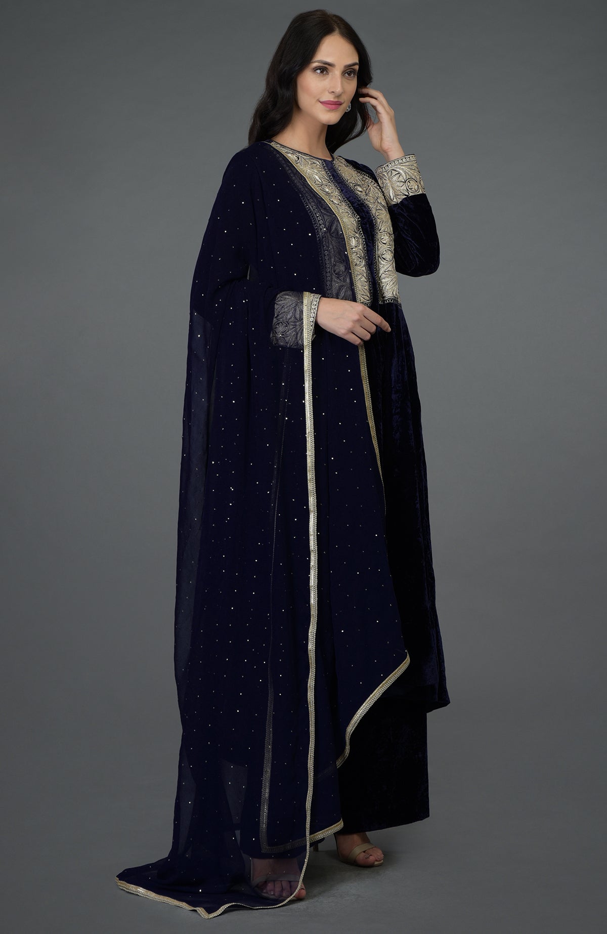 A woman models a midnight blue silk-velvet suit with silver Tilla embroidery.