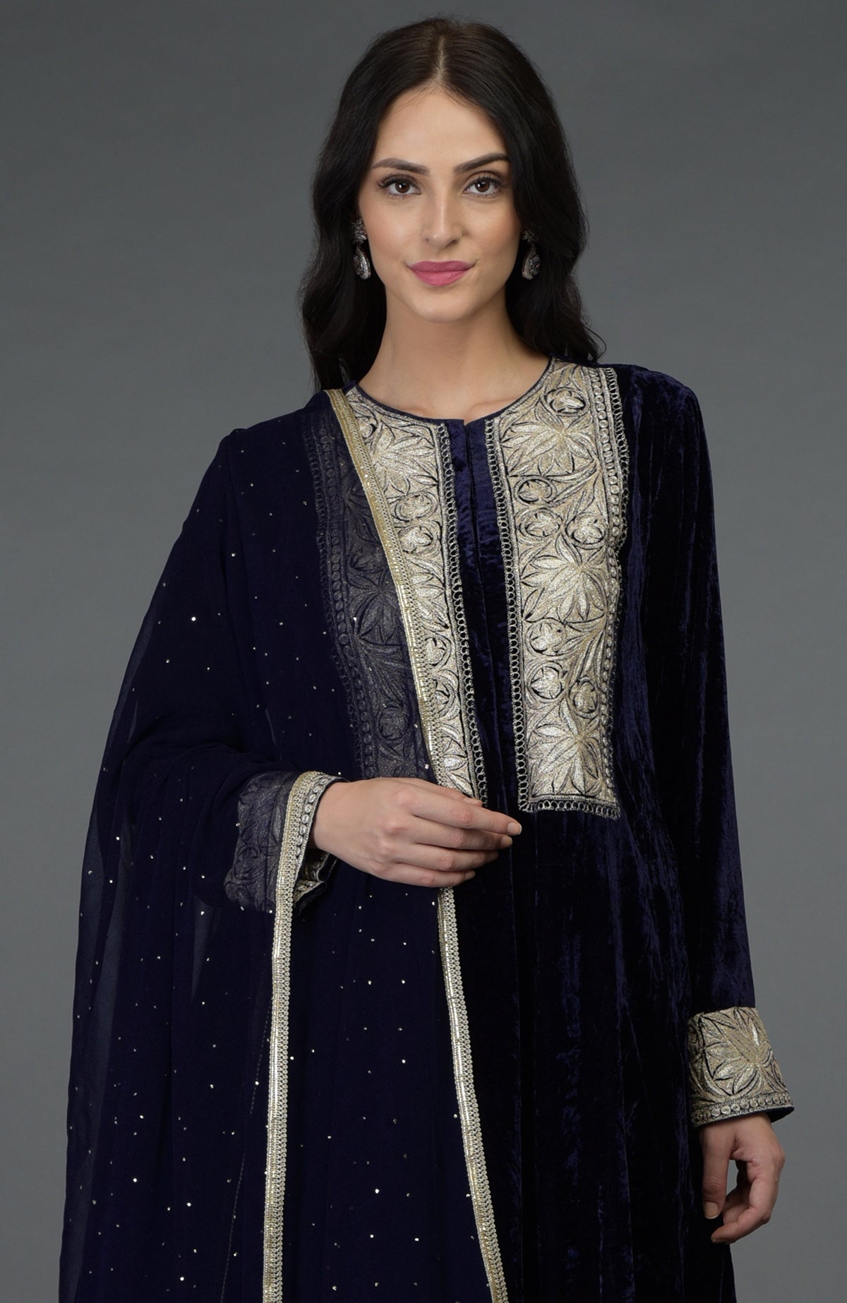 A woman models a midnight blue silk-velvet suit with silver Kashmiri Tilla embroidery.