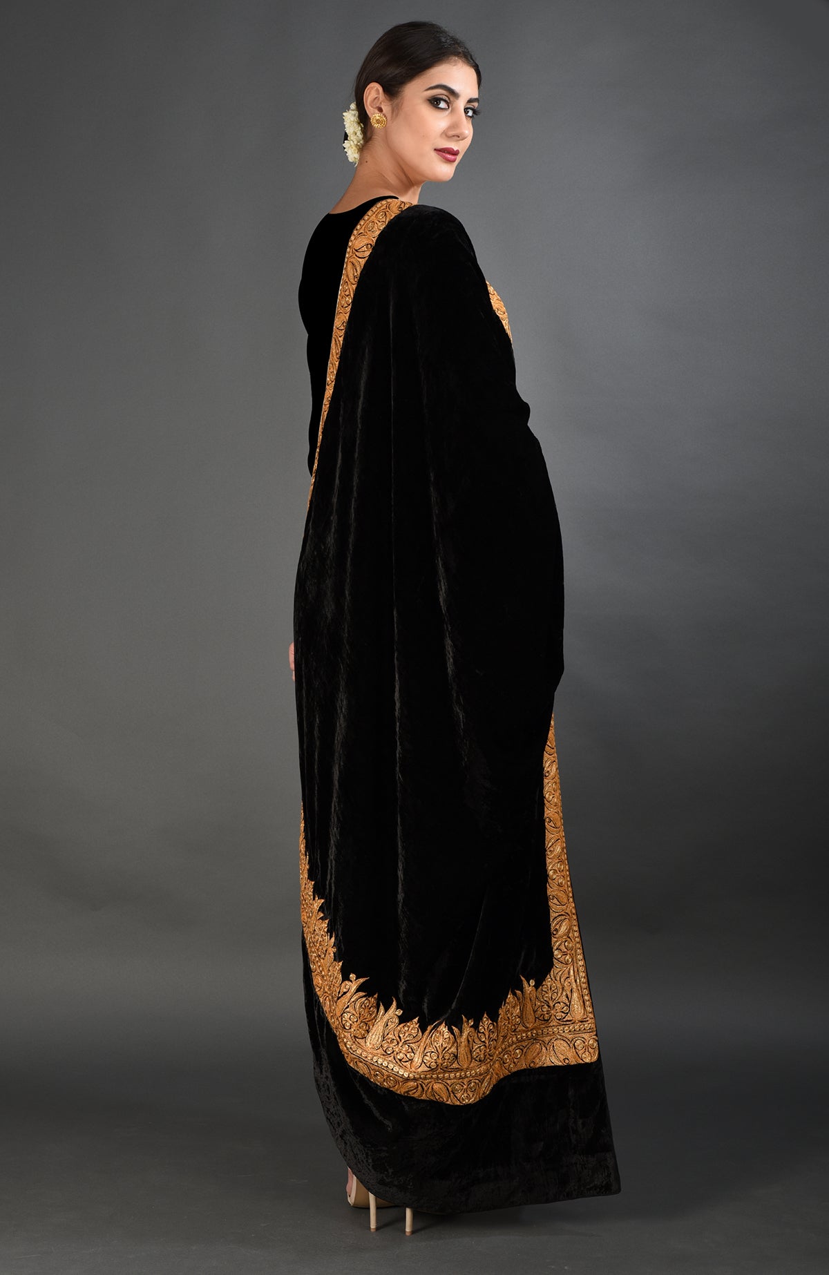 A woman models a black velvet dupatta shawl with gold Kashmiri Tilla embroidery.