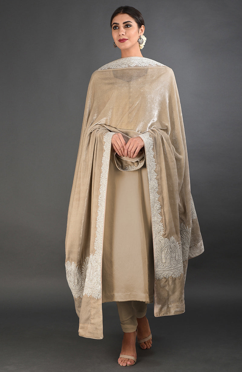 A woman models a beige Kashmiri Tilla embroidered dupatta and matching suit.