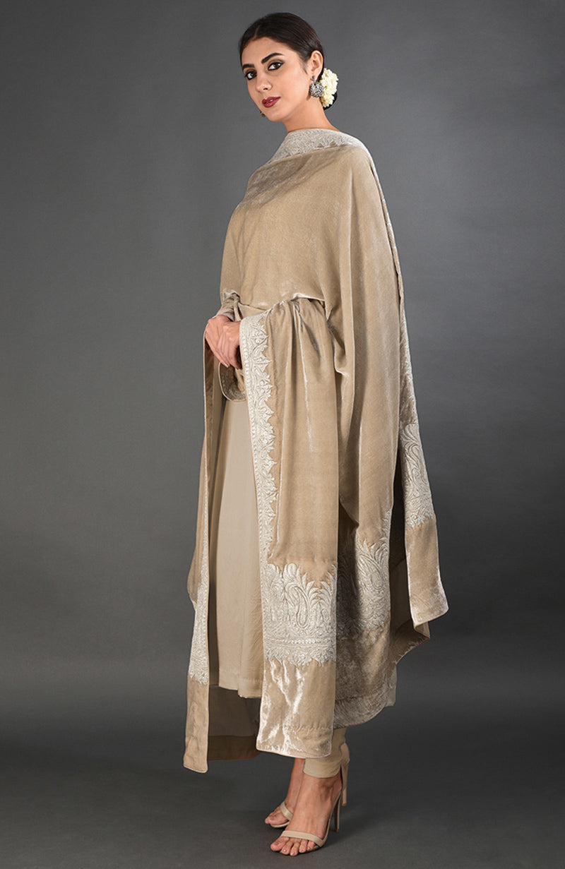 A woman models a beige velvet dupatta with silver Kashmiri tilla embroidery and a matching suit.