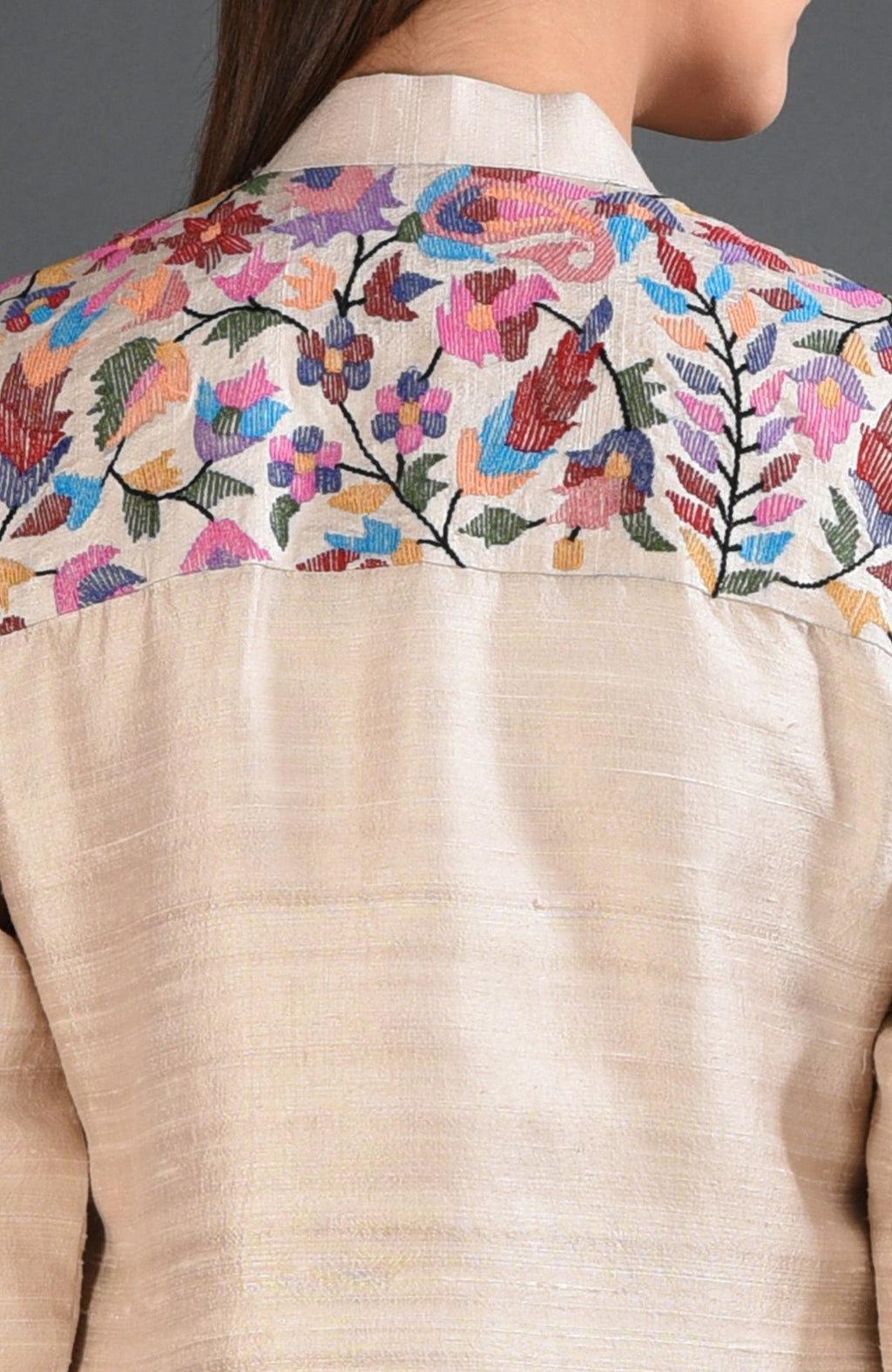 Creamy beige jacket with colorful floral and paisley embroidery on the back yoke.