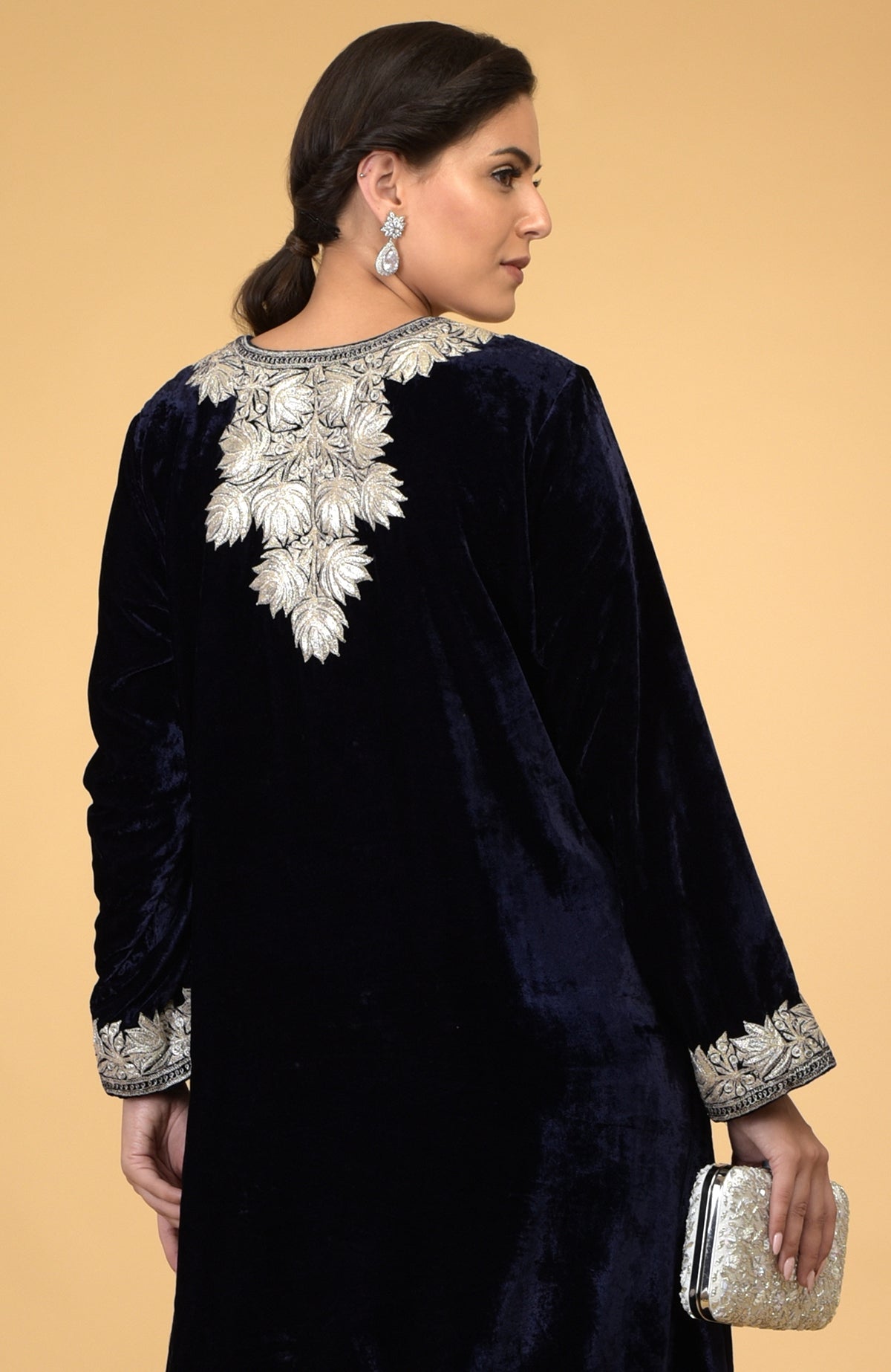 A woman models a midnight blue velvet kaftan with silver Kashmir embroidery.